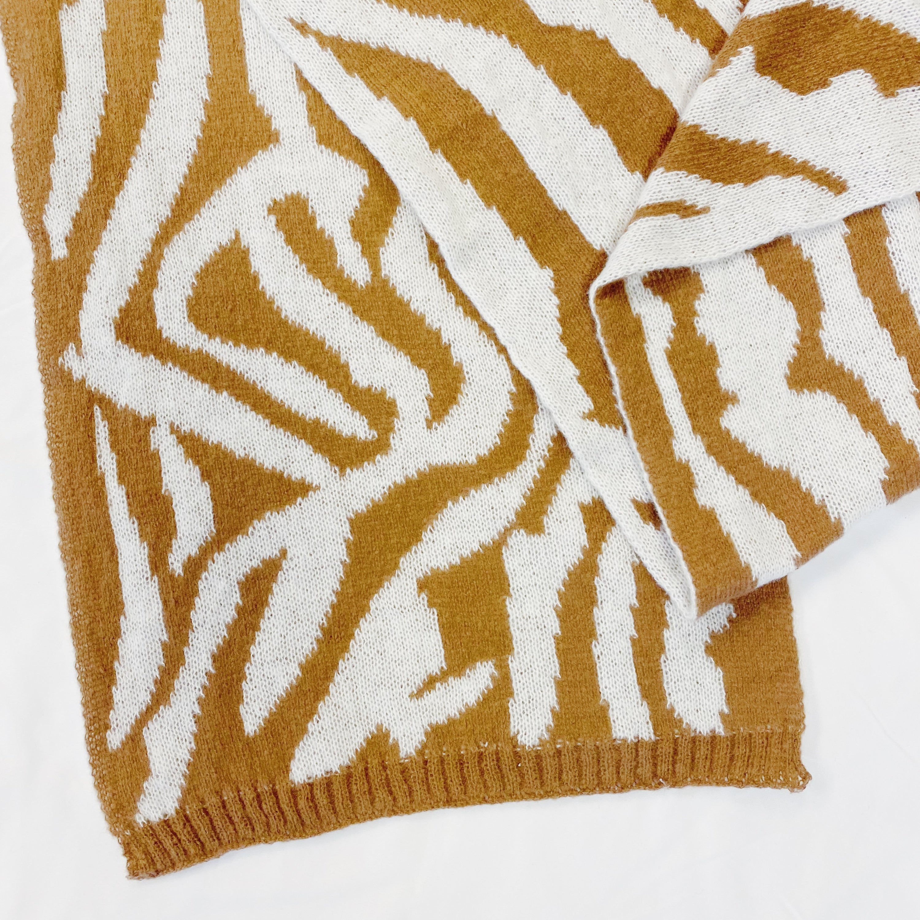 A cozy knit scarf featuring a trendy zebra pattern, reversible for versatile styling, measuring approximately 13 inches by 78 inches.