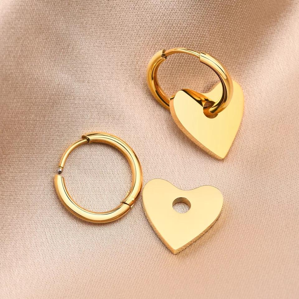 A pair of Dee Heart Earrings featuring a 2-in-1 hoop design with a heart charm, elegantly crafted in 18k gold plated stainless steel.