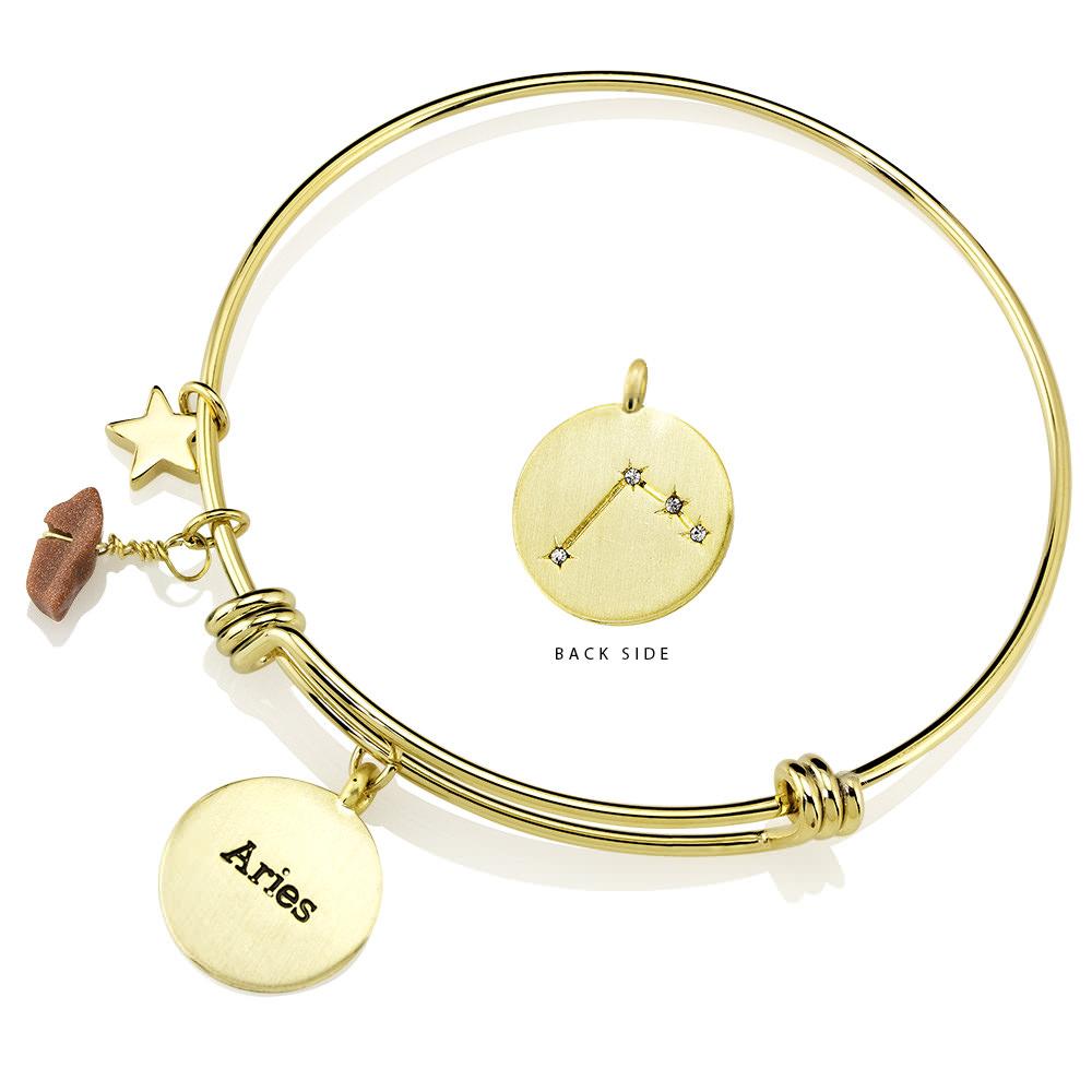 Elegant gold-plated bangle featuring zodiac charms and simulated diamonds, perfect for astrology lovers.