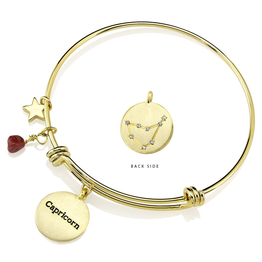 Elegant gold-plated bangle featuring zodiac charms and simulated diamonds, perfect for astrology lovers.