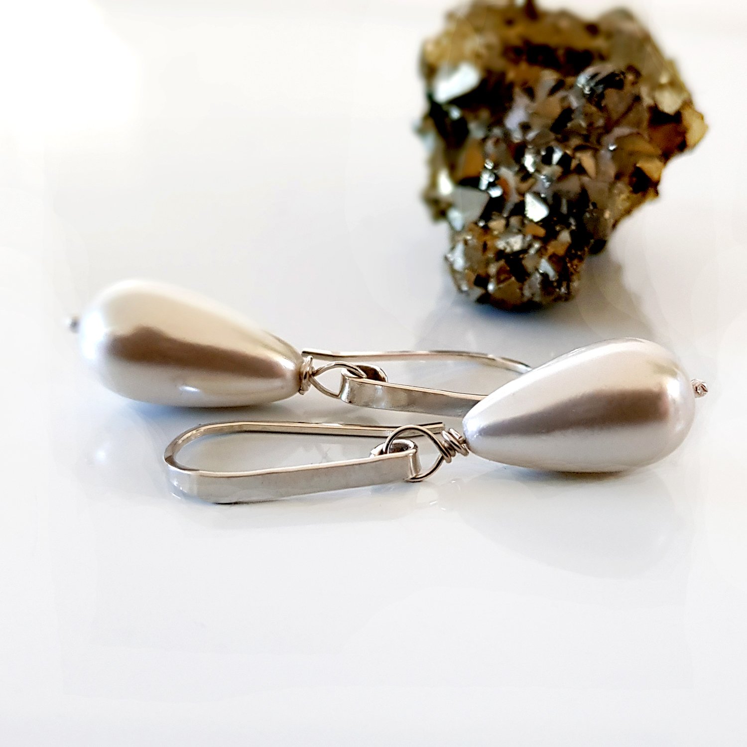 Elegant Dew Drop earrings featuring teardrop shell pearls on artisan hooks, perfect for bridal and formal occasions.