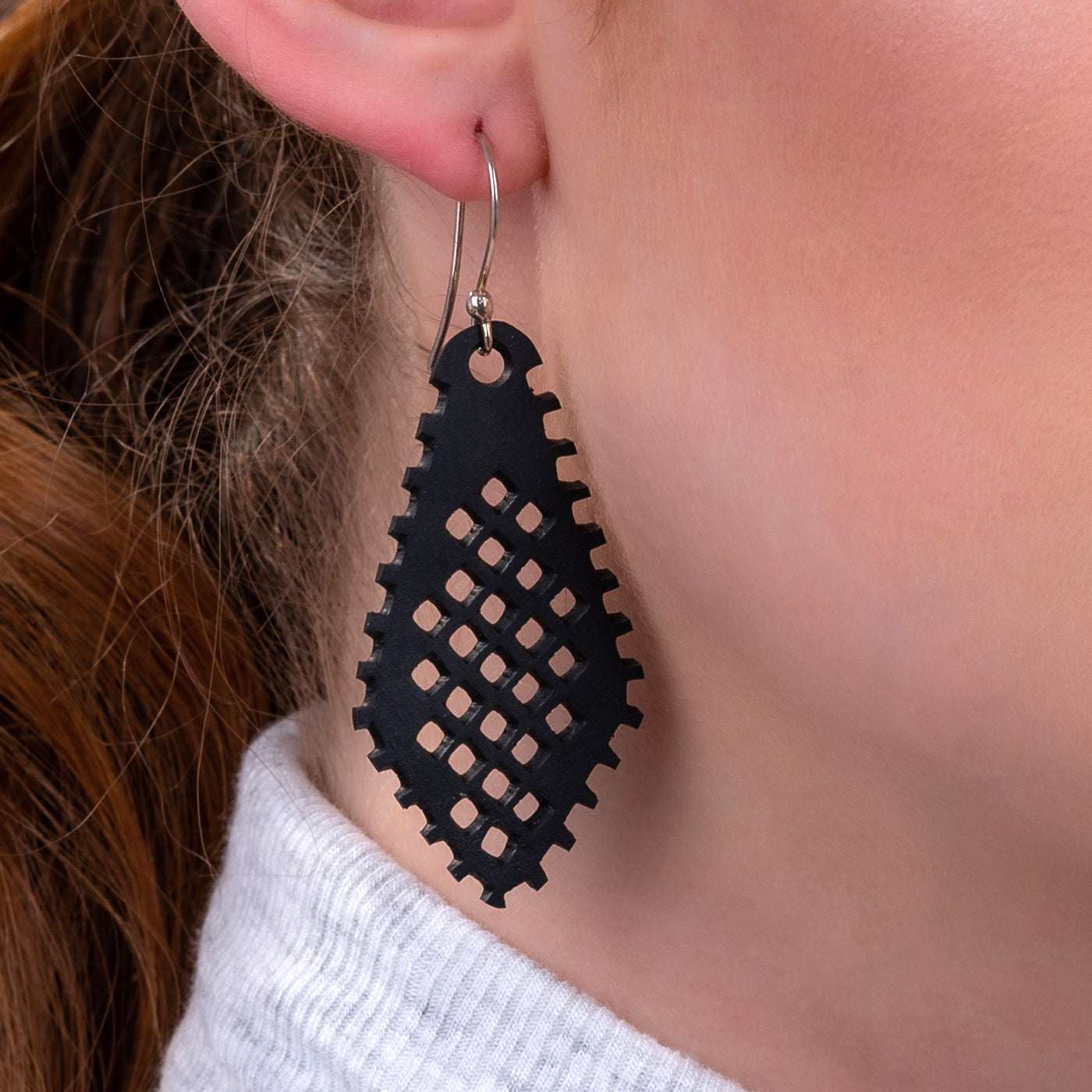 A pair of handcrafted Diamond Recycled Rubber Earrings made from reclaimed tyre inner tubes, featuring unique designs and sterling silver hooks.