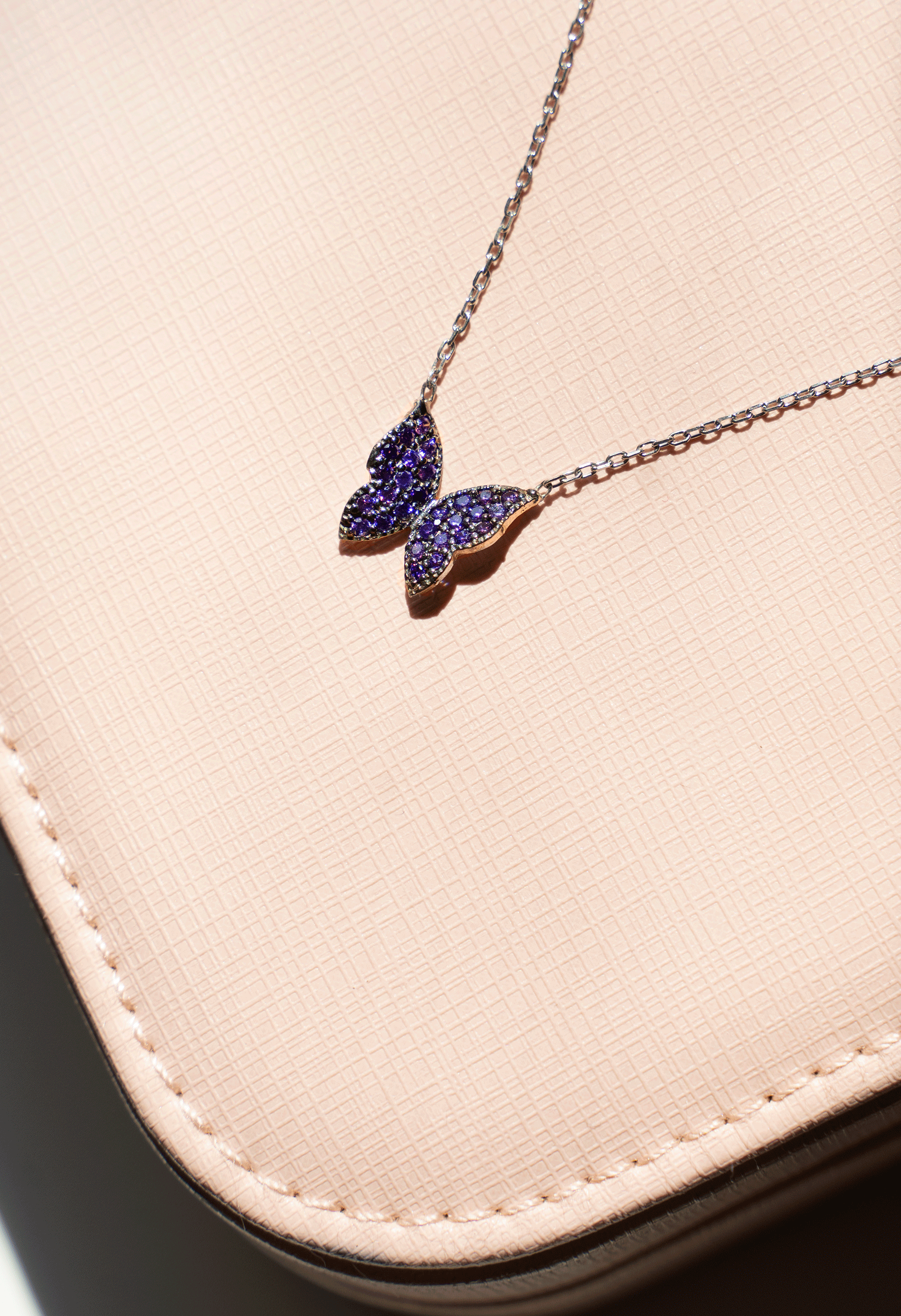 A shiny DIANA Butterfly Necklace featuring round brilliant cut amethysts set in 925 sterling silver, showcasing a delicate chain.