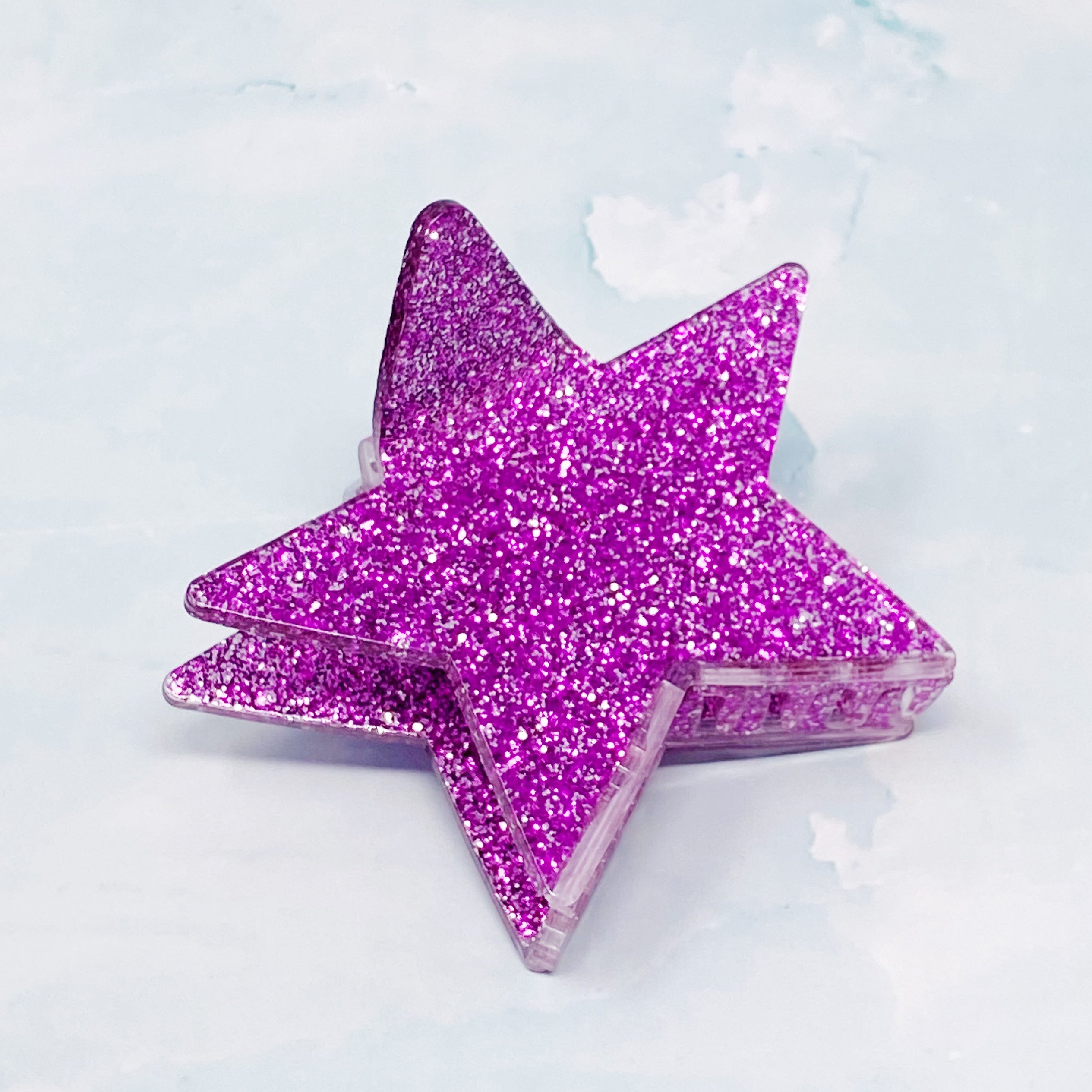 A glittery star-shaped hair claw in sparkling colors, perfect for festive hairstyles.