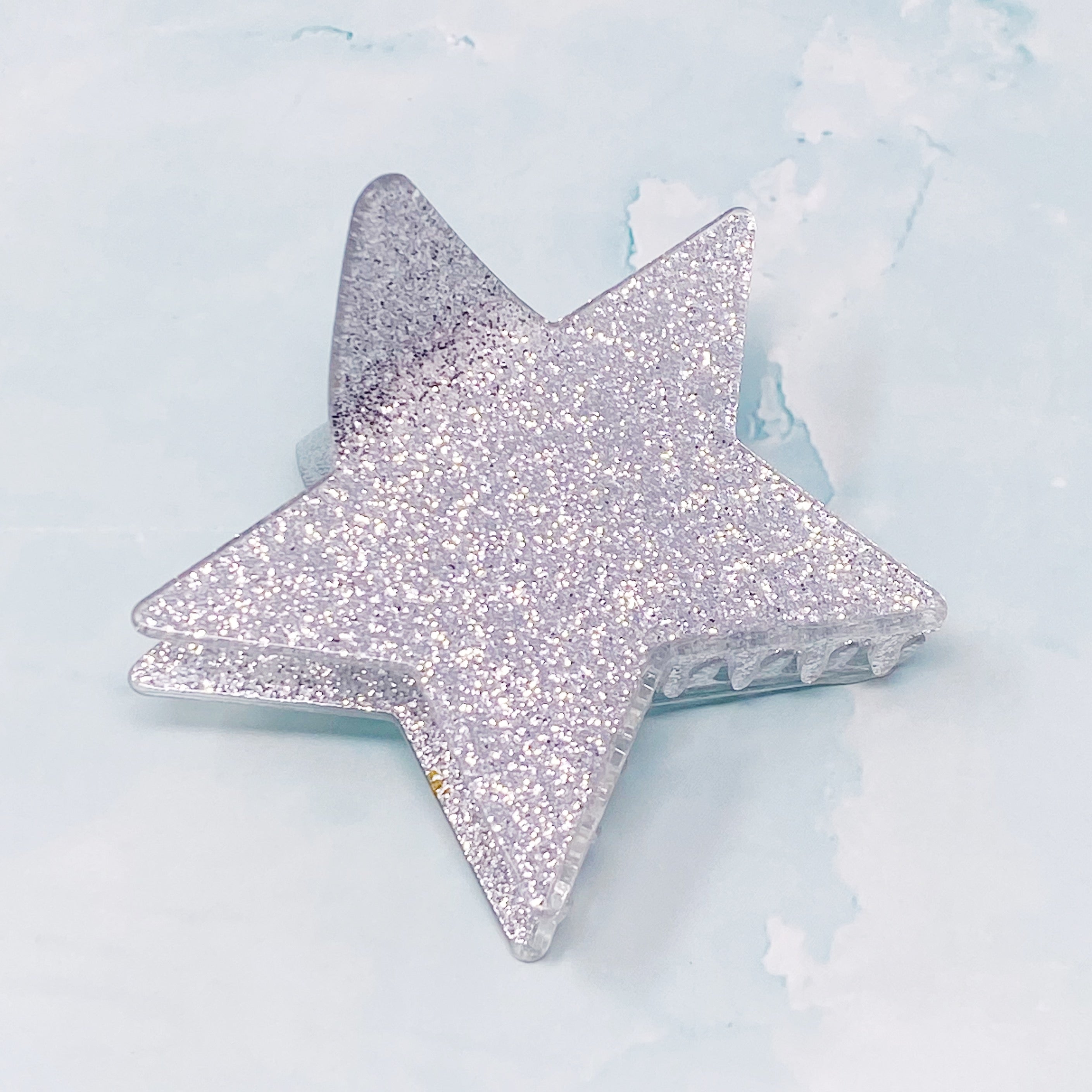 A glittery star-shaped hair claw in sparkling colors, perfect for festive hairstyles.