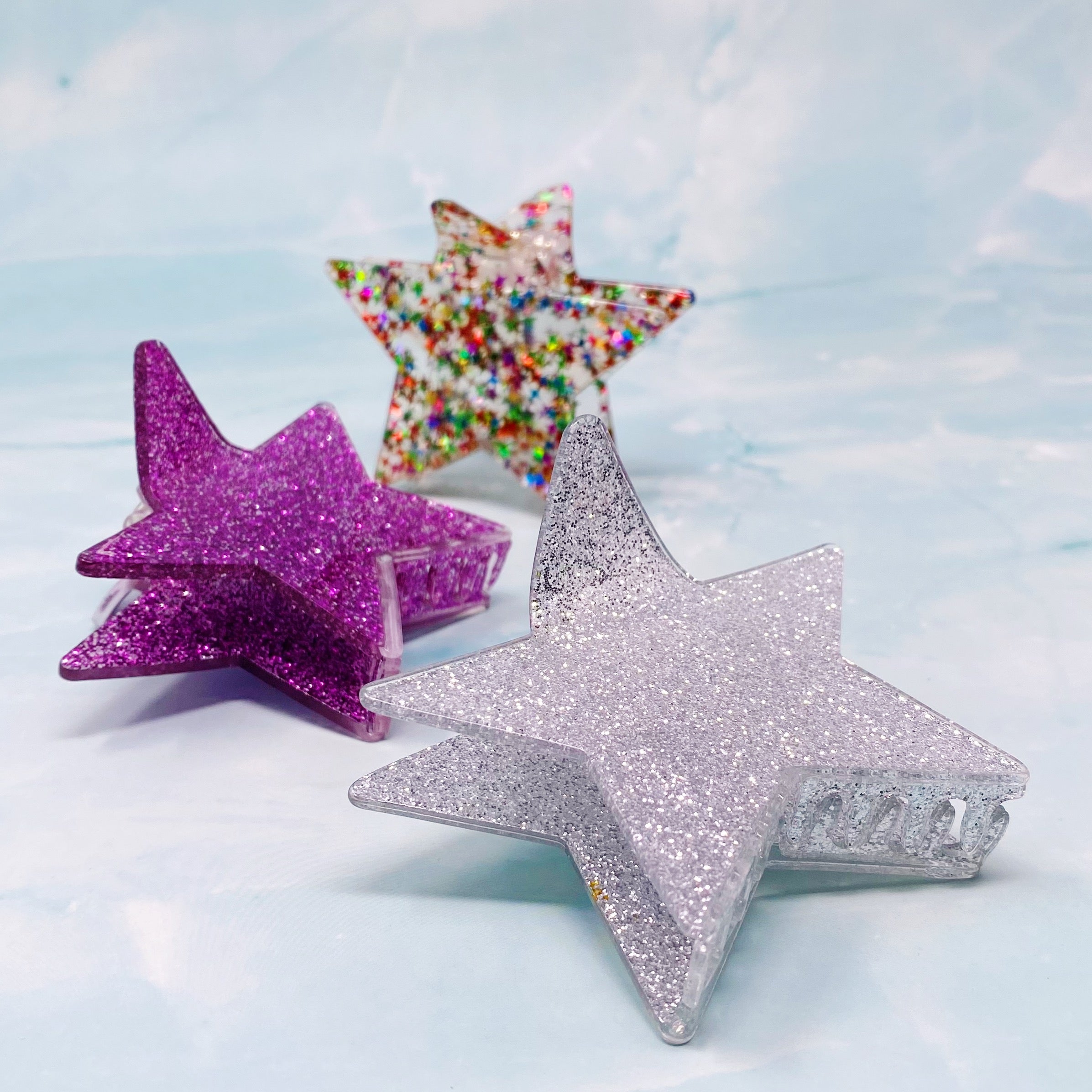 A glittery star-shaped hair claw in sparkling colors, perfect for festive hairstyles.