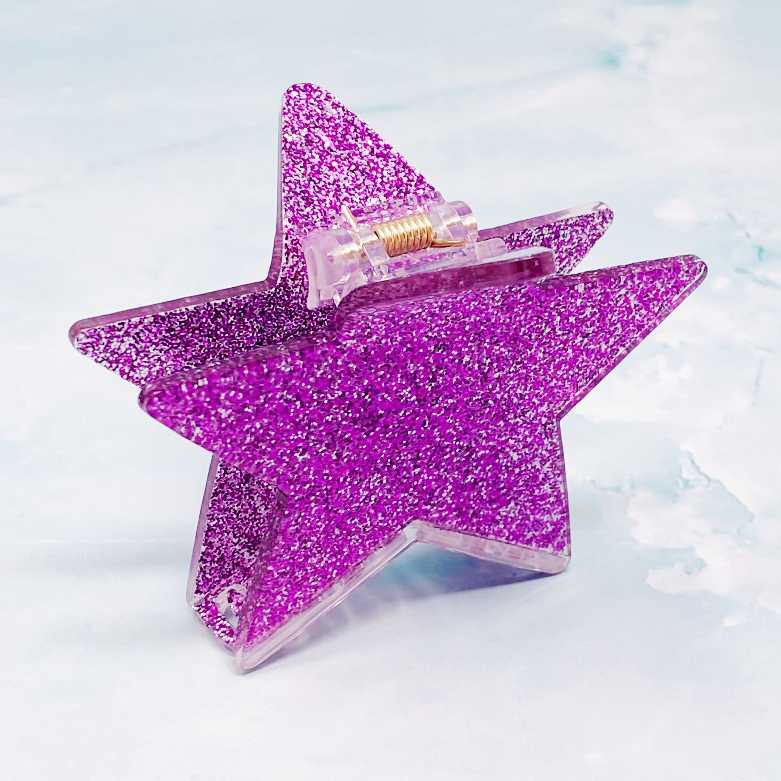 A glittery star-shaped hair claw in sparkling colors, perfect for festive hairstyles.