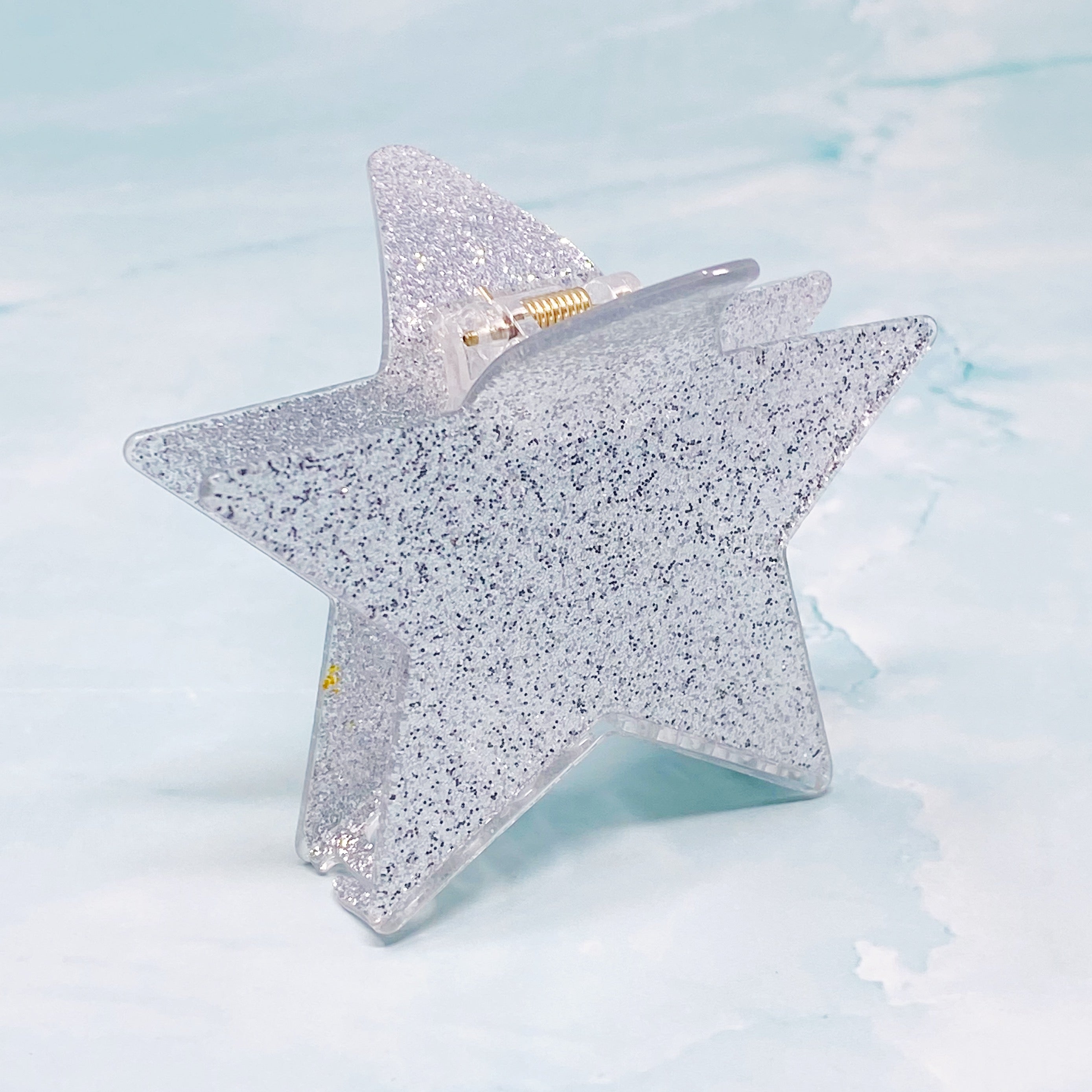 A glittery star-shaped hair claw in sparkling colors, perfect for festive hairstyles.