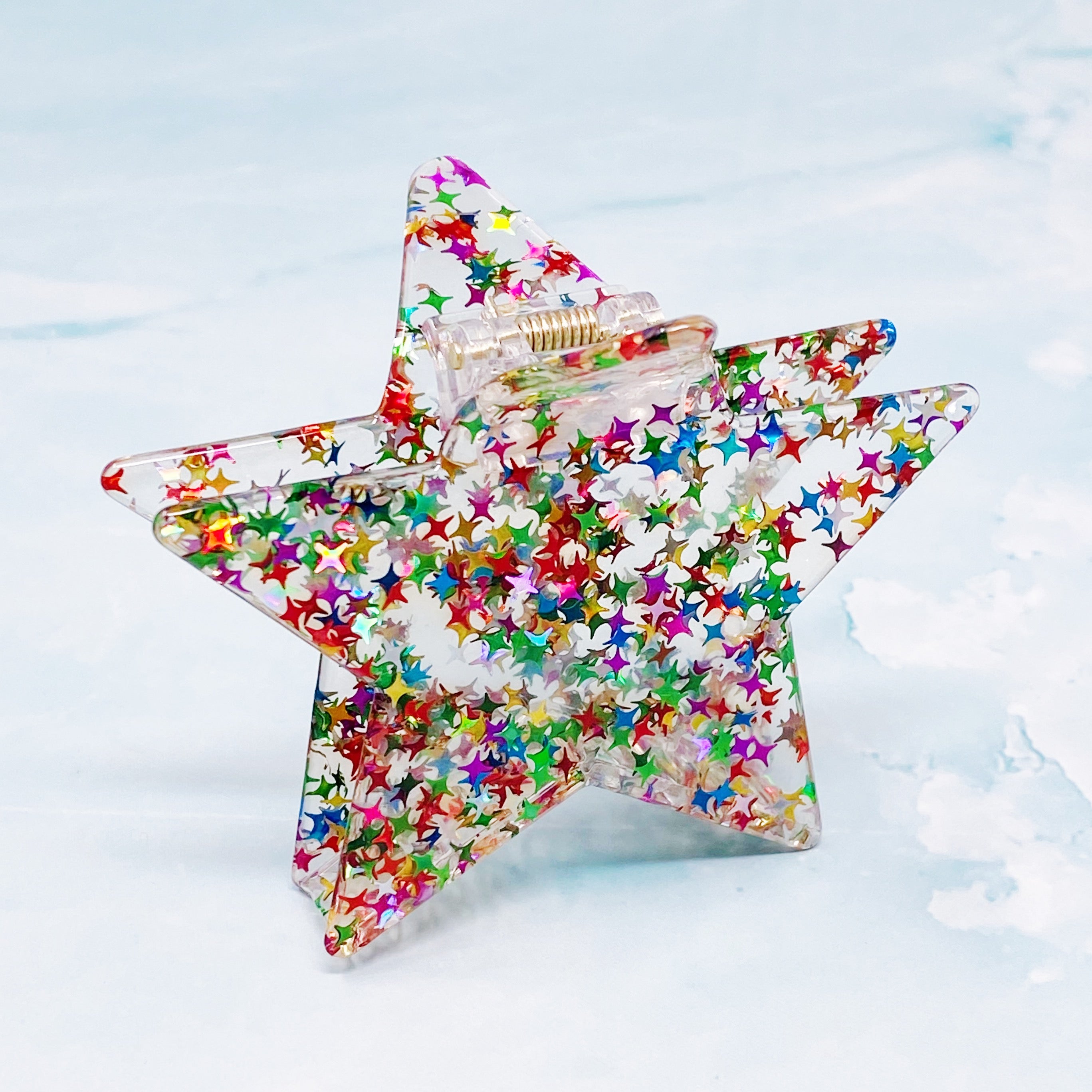 A glittery star-shaped hair claw in sparkling colors, perfect for festive hairstyles.