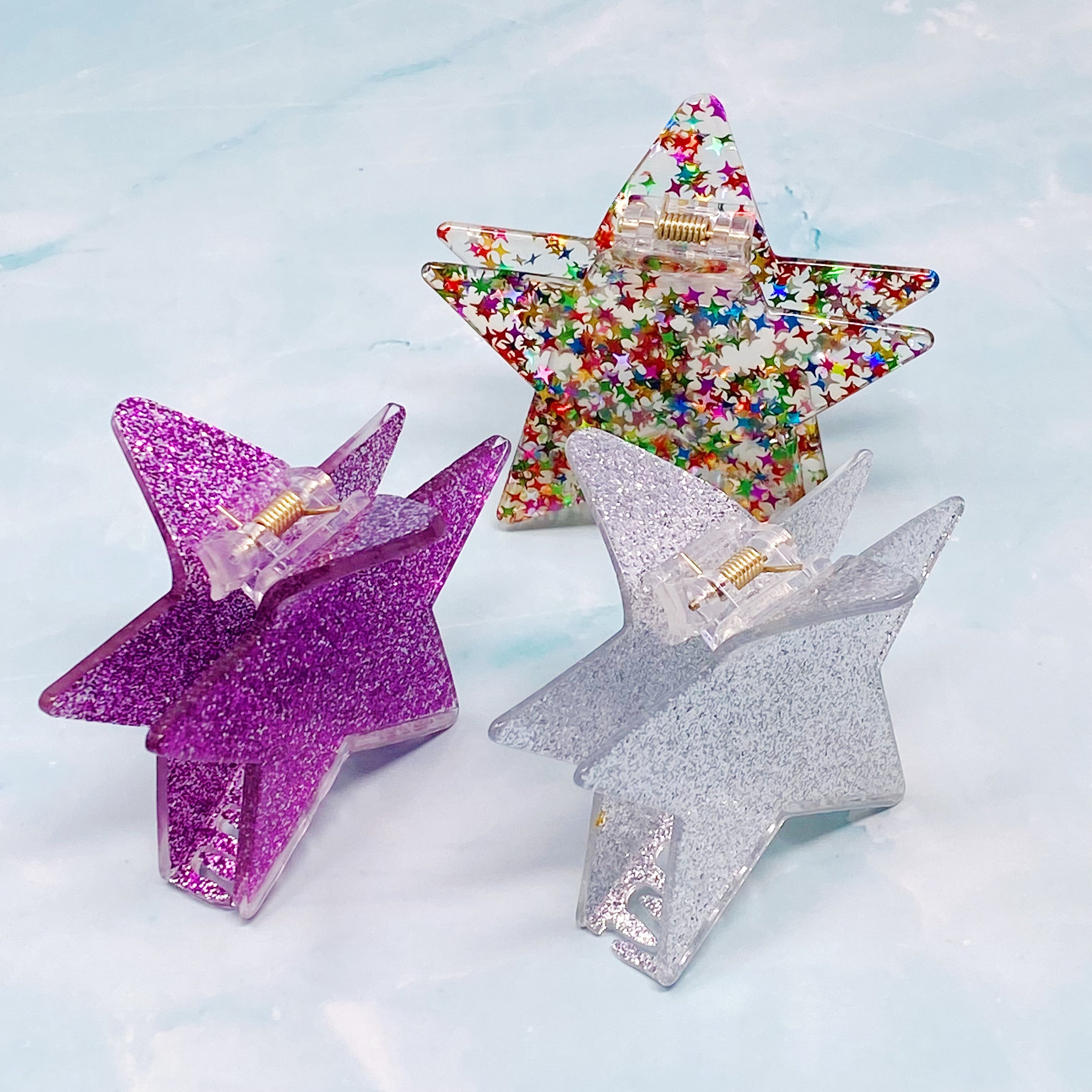 A glittery star-shaped hair claw in sparkling colors, perfect for festive hairstyles.