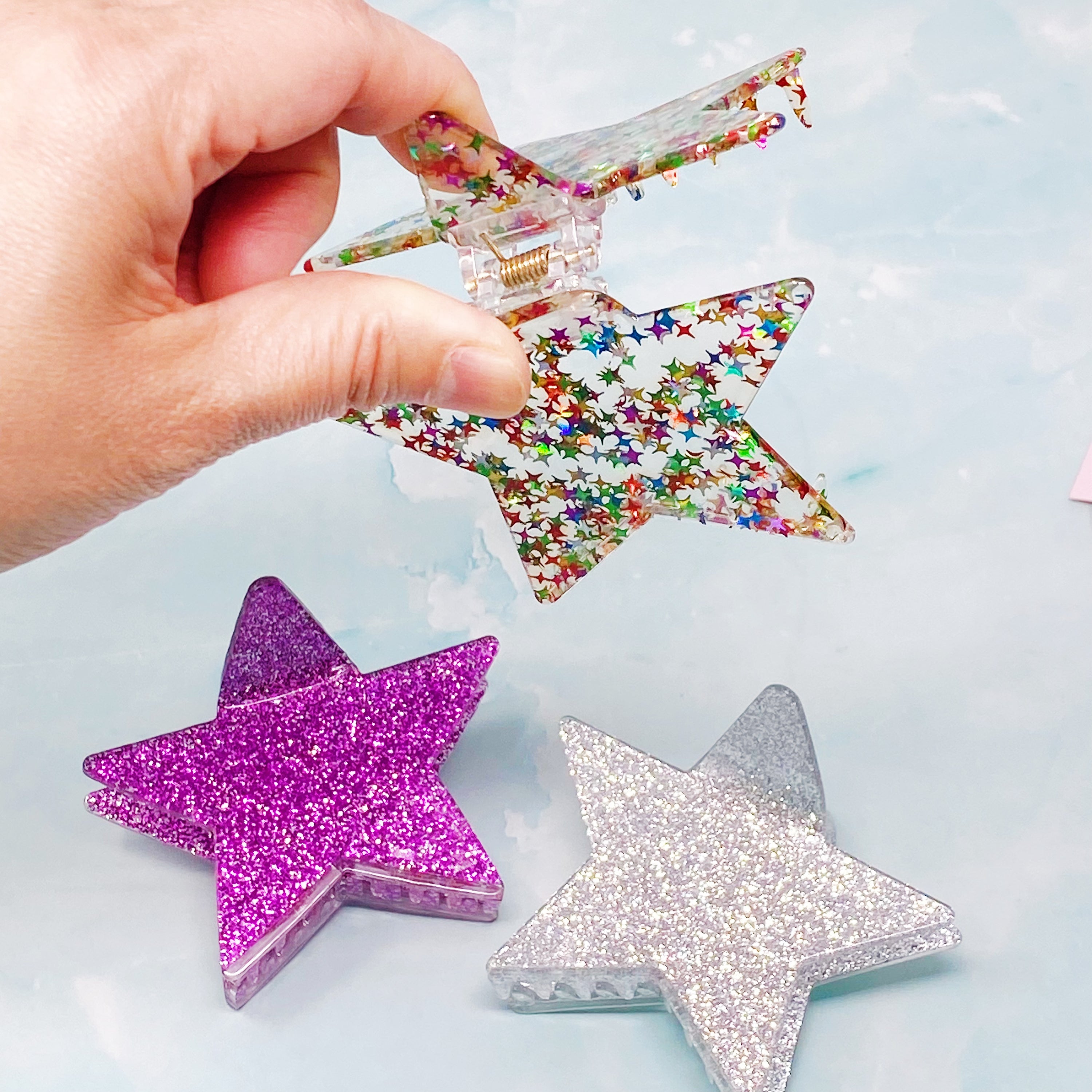 A glittery star-shaped hair claw in sparkling colors, perfect for festive hairstyles.