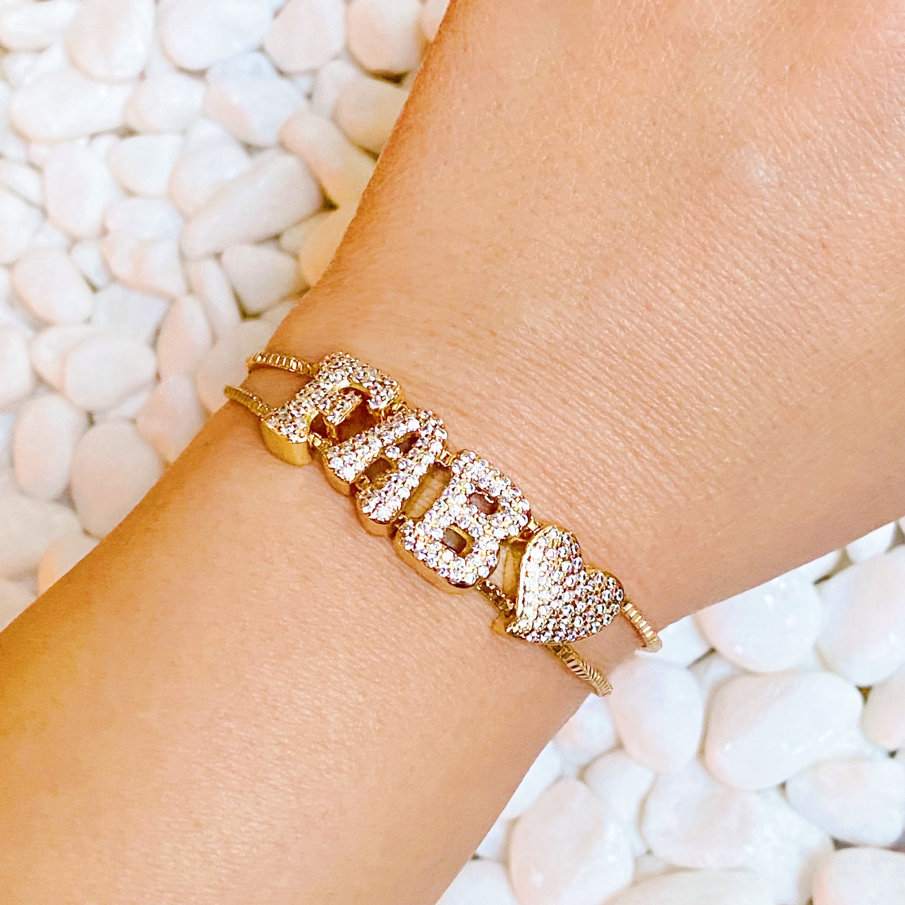 A sparkling Disco Dazzle Bracelet featuring a fun font design and adjustable drawstring chain, embellished with cubic zirconia accents.