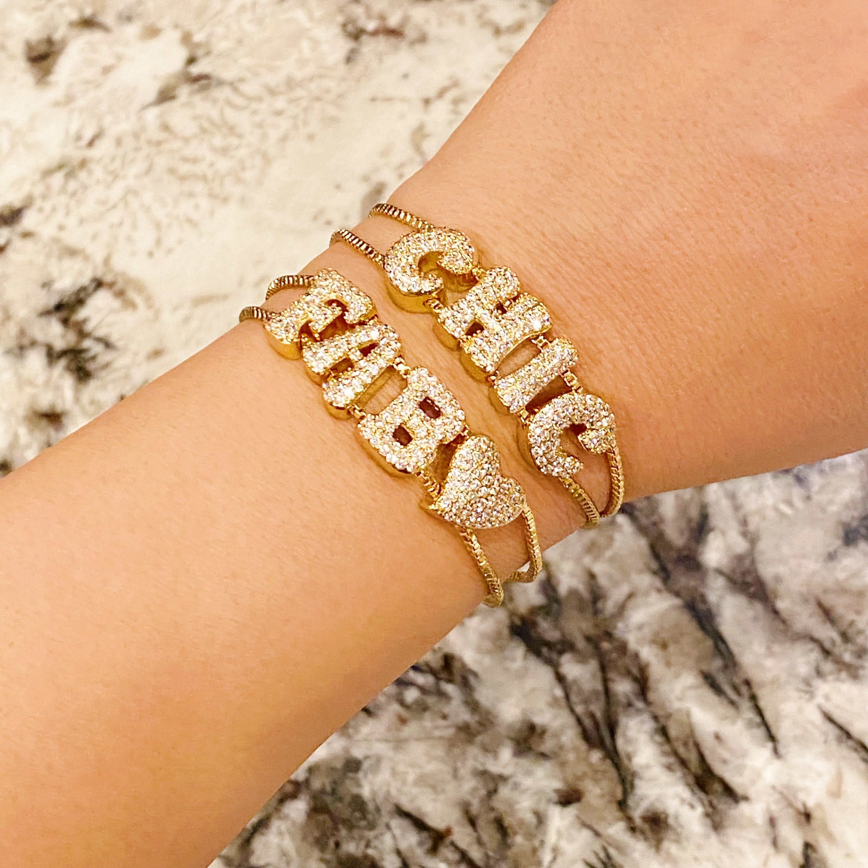 A sparkling Disco Dazzle Bracelet featuring a fun font design and adjustable drawstring chain, embellished with cubic zirconia accents.