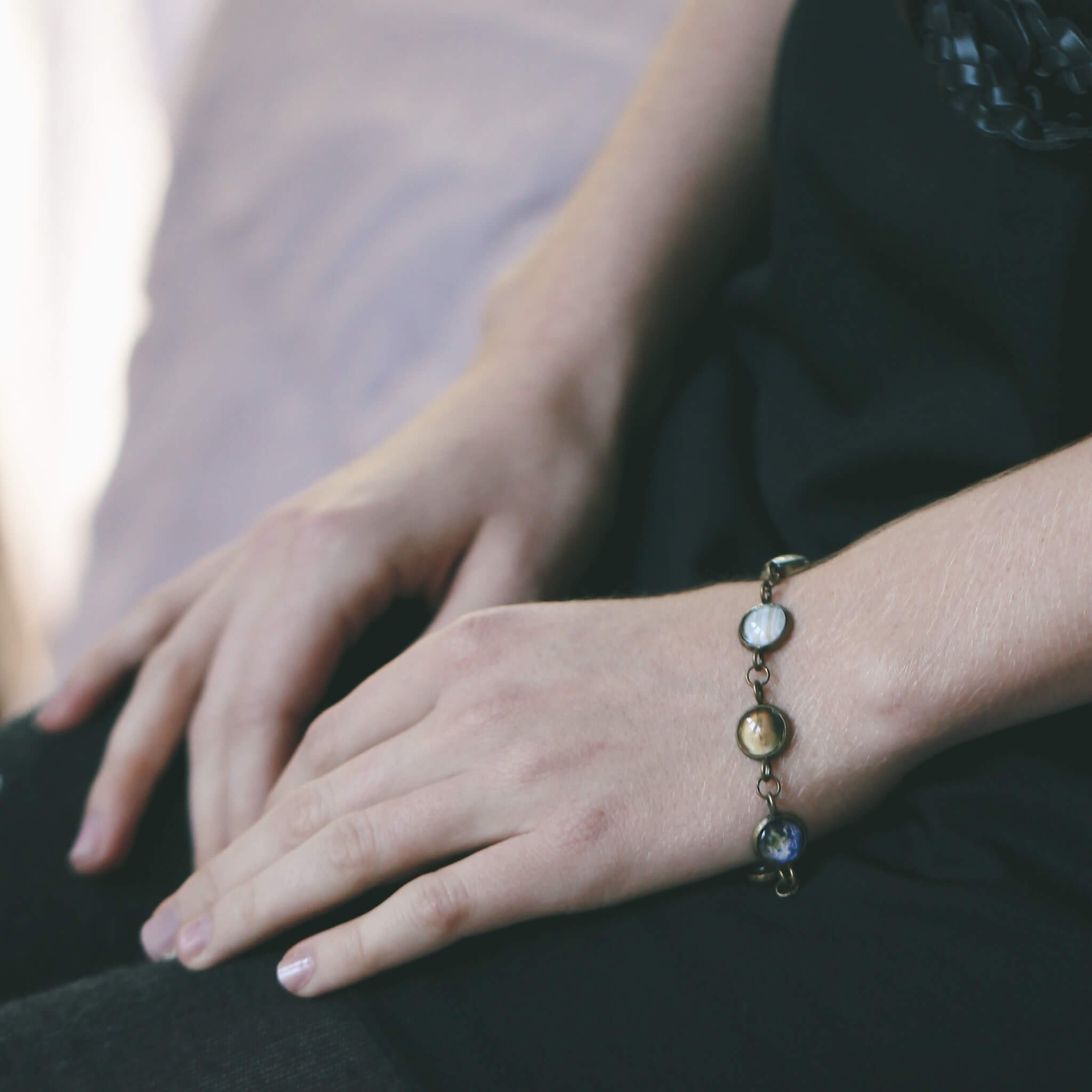 Solar System Galaxy Bracelet featuring planets in antique silver and bronze tones, handcrafted with plated brass and glass.