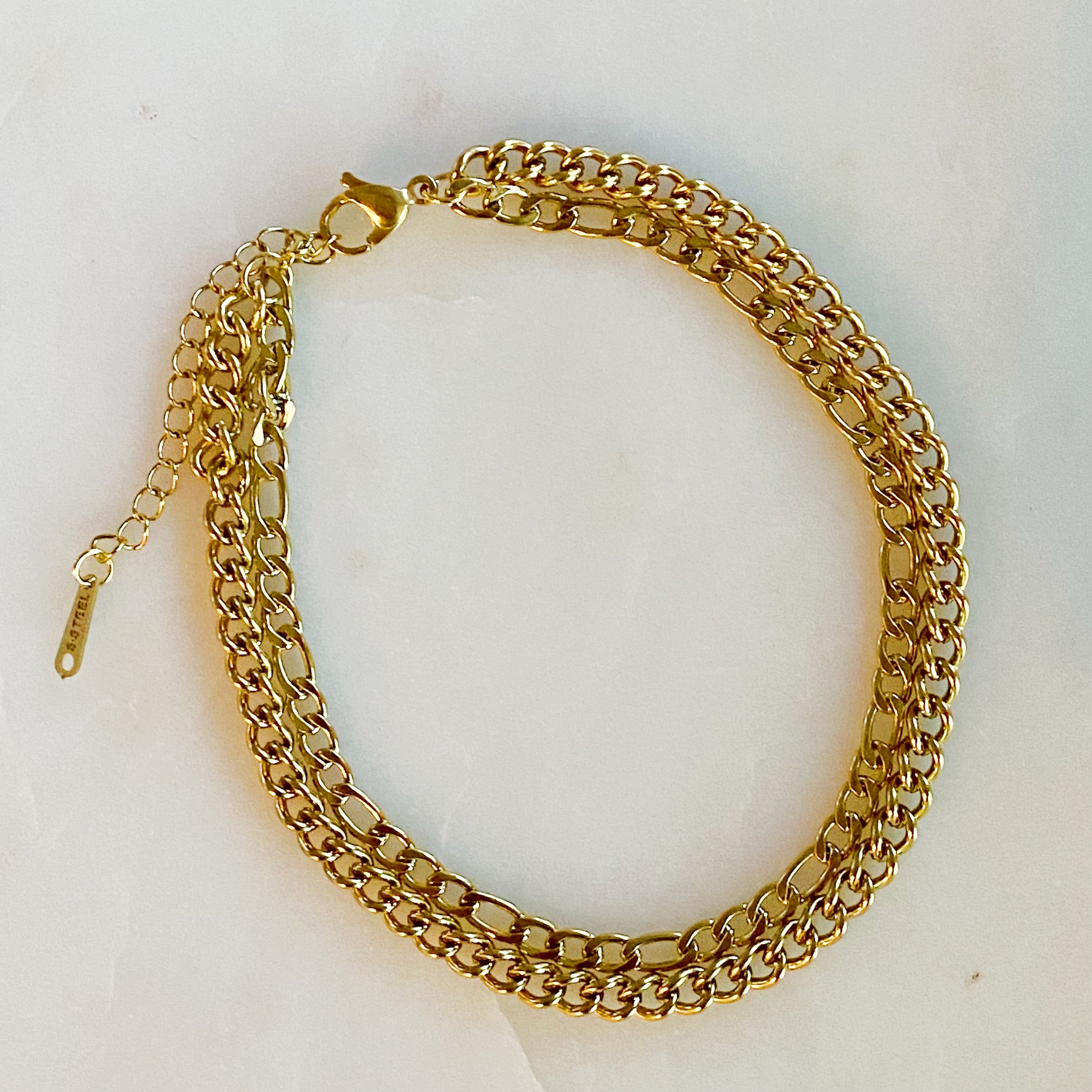 Stylish double chain anklet with gold plated stainless steel, featuring two chains of different lengths for a unique look.