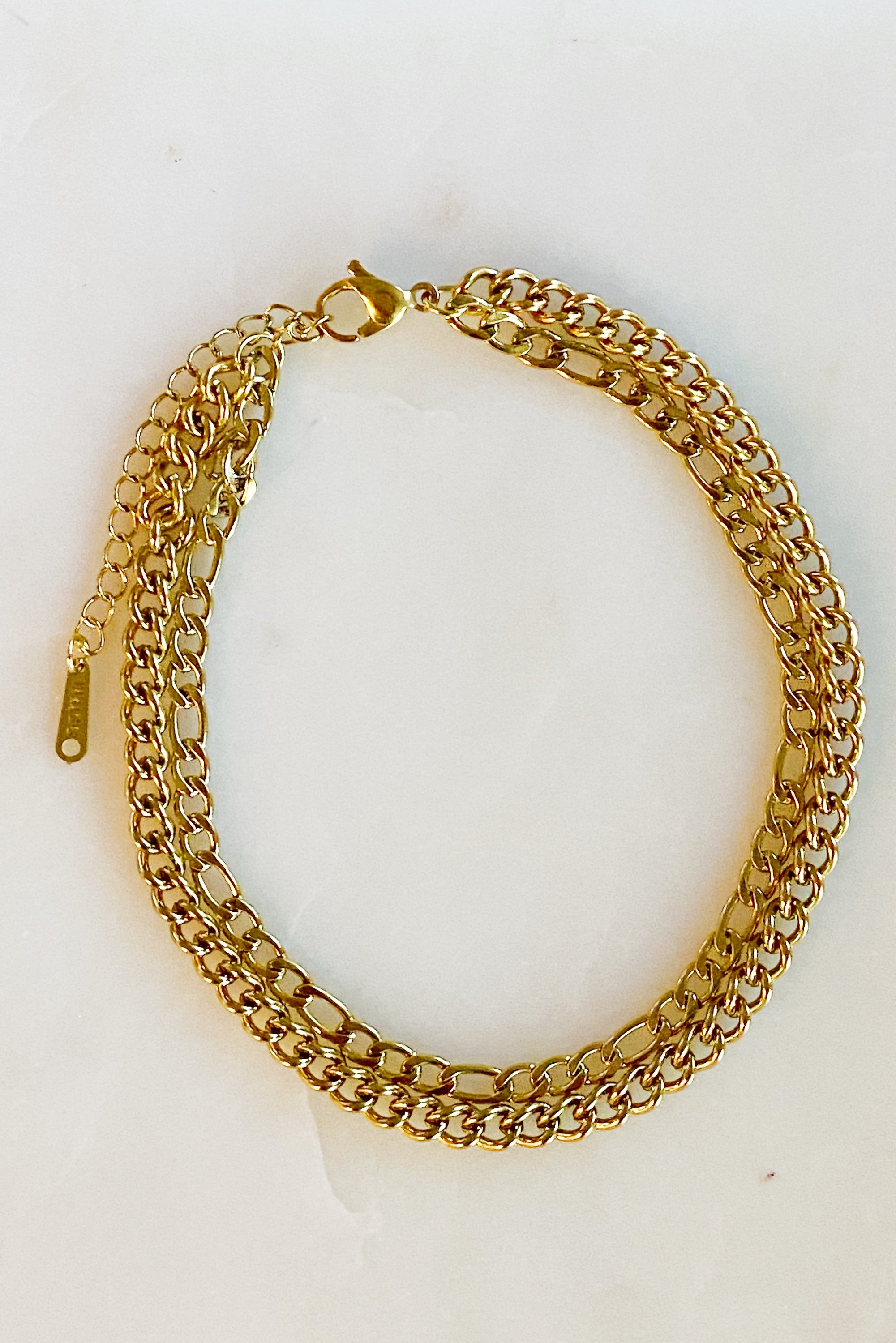 Stylish double chain anklet with gold plated stainless steel, featuring two chains of different lengths for a unique look.