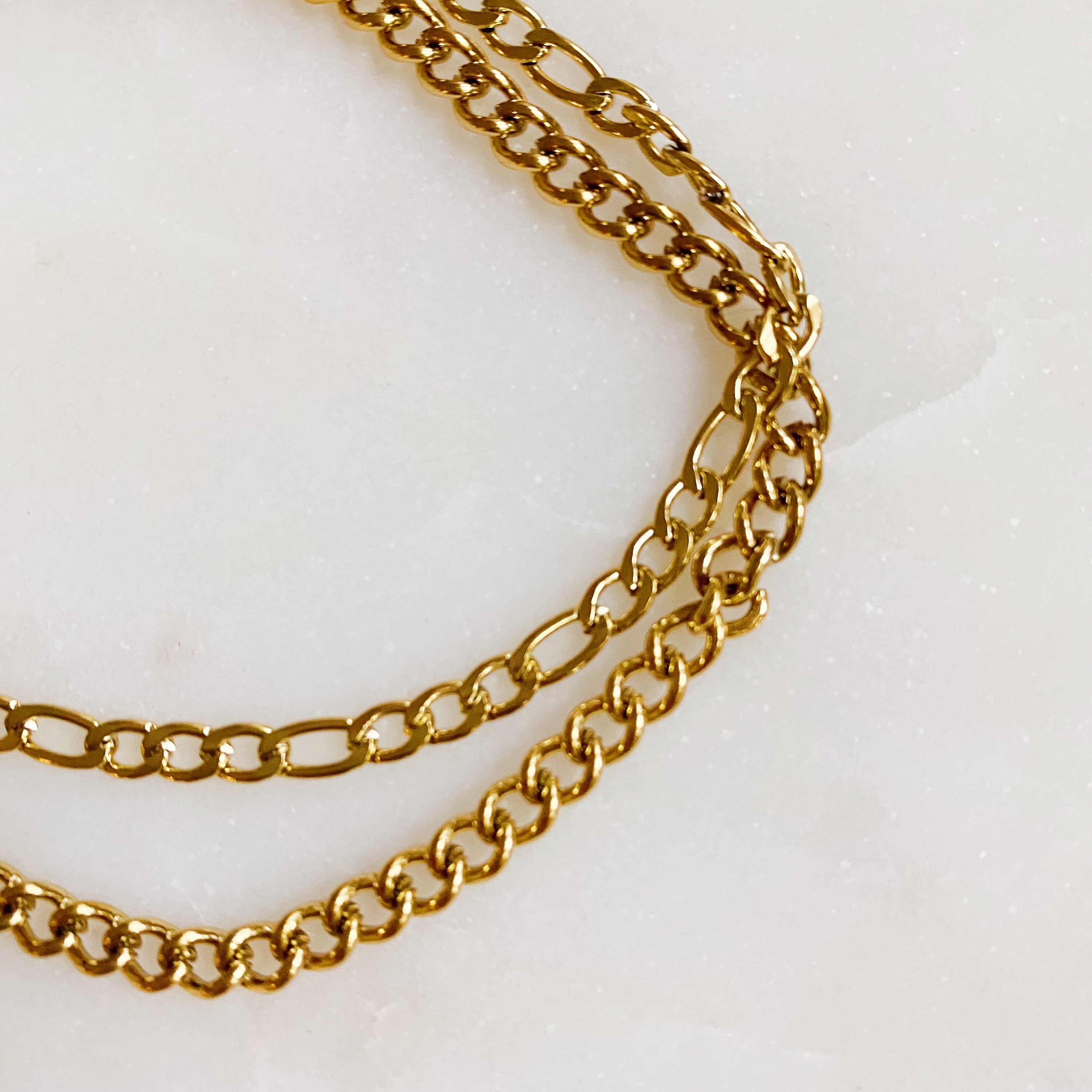 Stylish double chain anklet with gold plated stainless steel, featuring two chains of different lengths for a unique look.