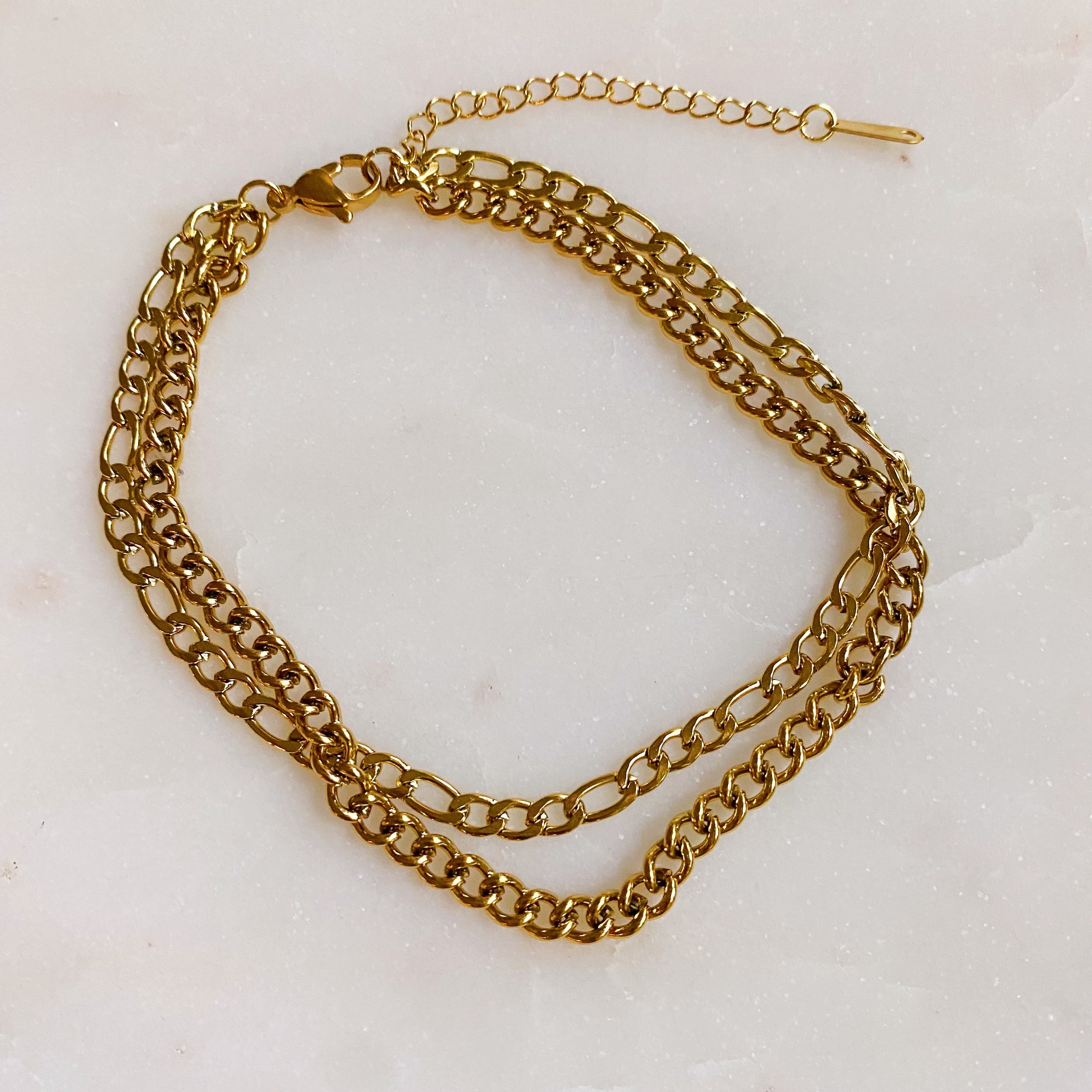 Stylish double chain anklet with gold plated stainless steel, featuring two chains of different lengths for a unique look.