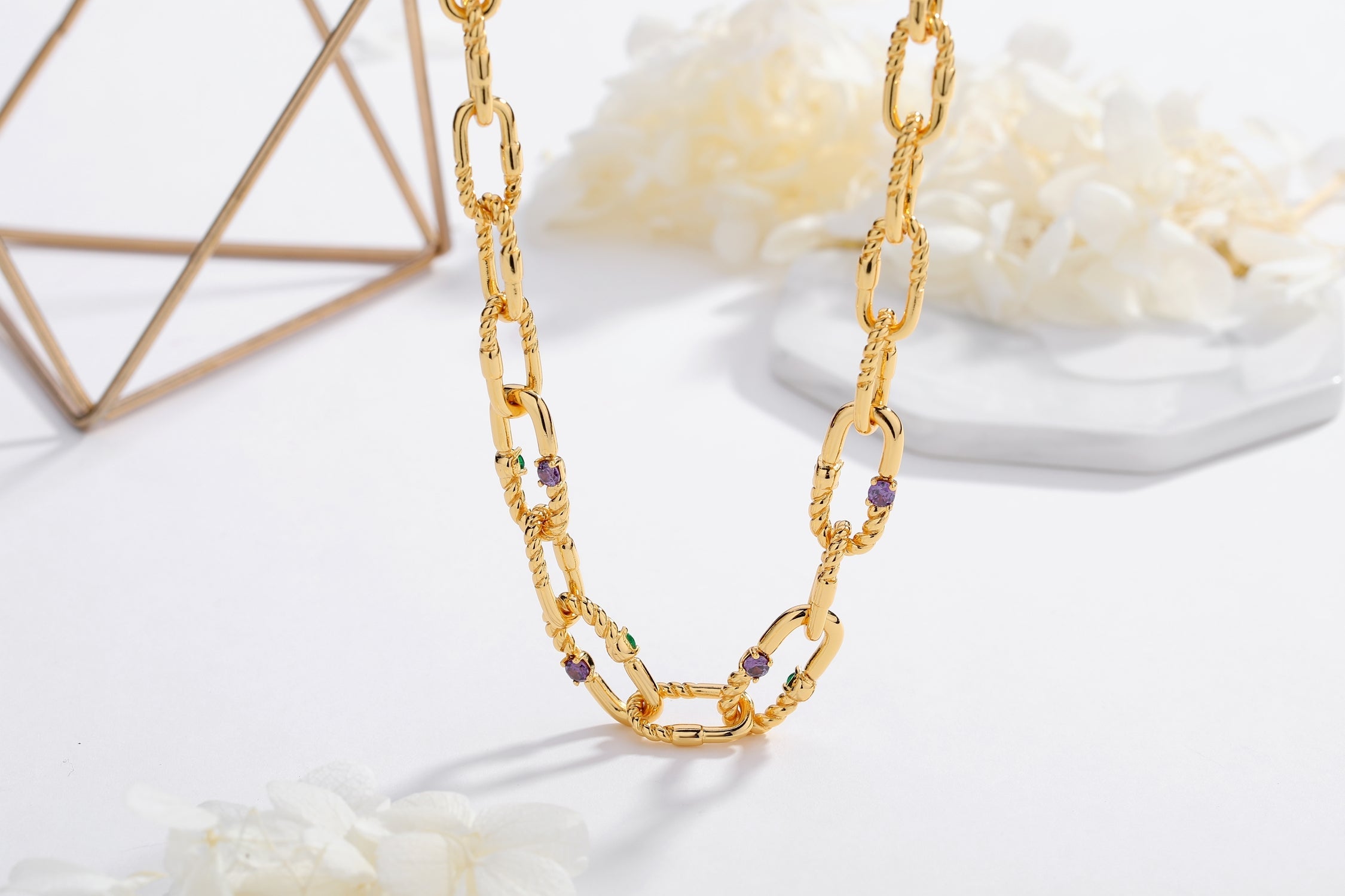 A stylish Double Colored Zirconia Gold Chain Necklace featuring green and purple cubic zirconia stones set in a paperclip link design.