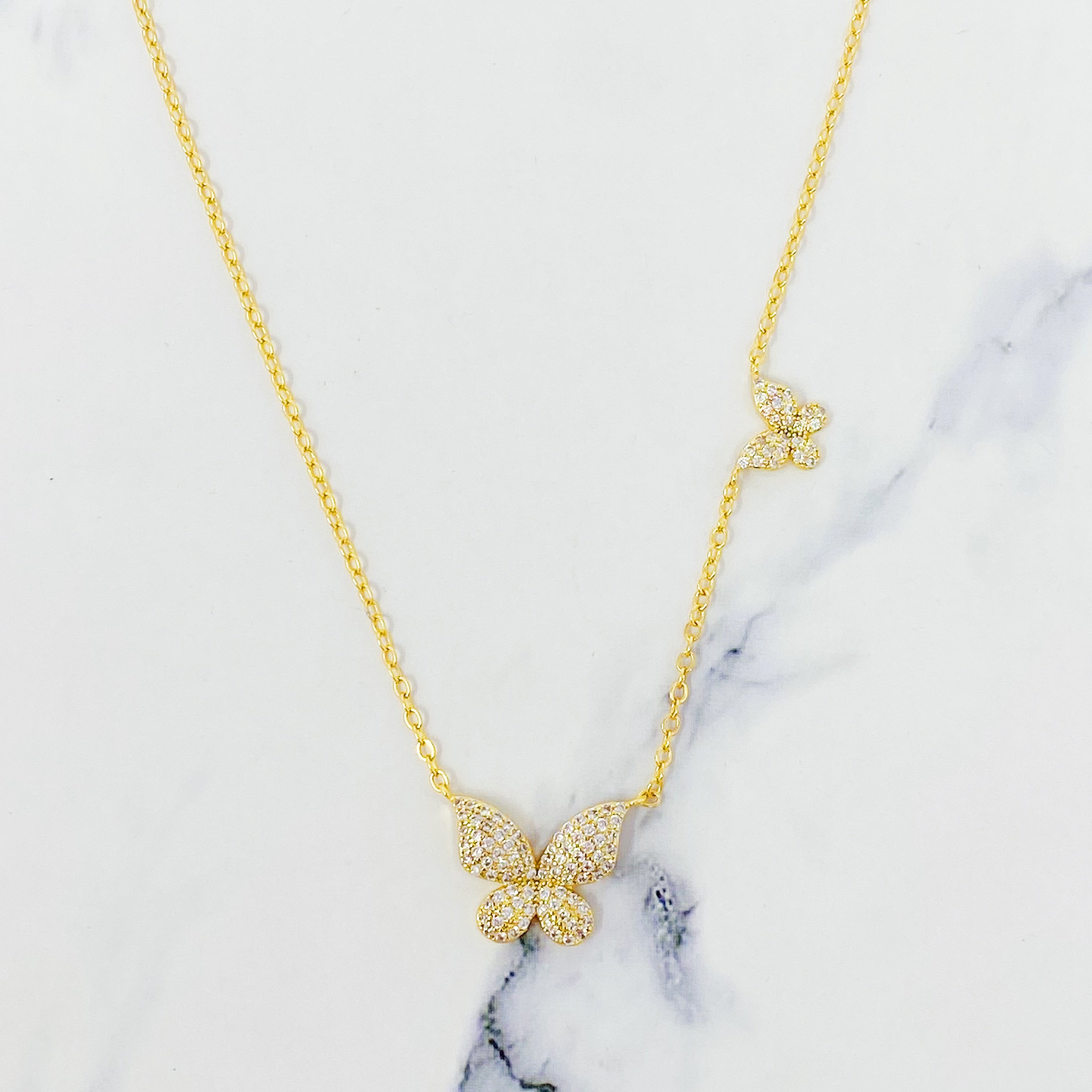 Double Shine Butterfly Necklace featuring two sparkling butterfly pendants on a gold tone chain.