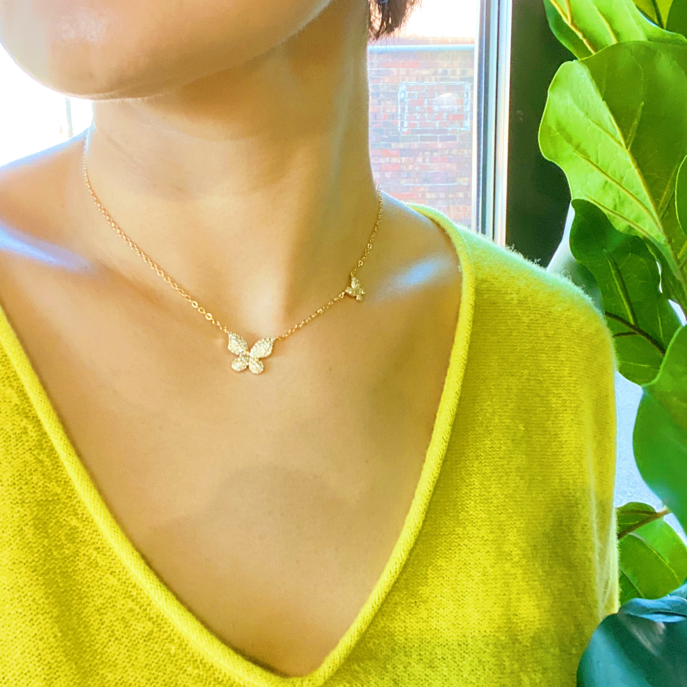 Double Shine Butterfly Necklace featuring two sparkling butterfly pendants on a gold tone chain.