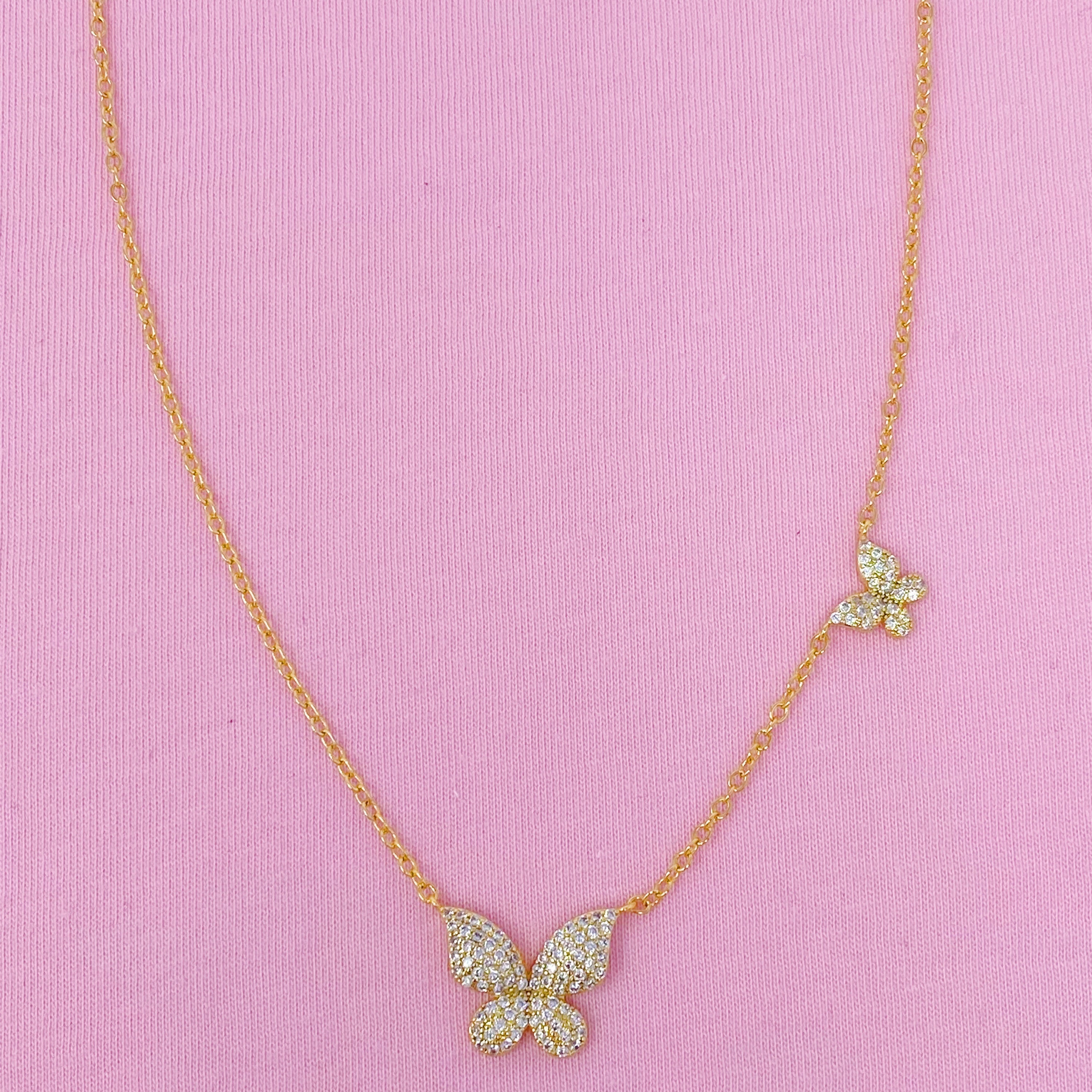 Double Shine Butterfly Necklace featuring two sparkling butterfly pendants on a gold tone chain.