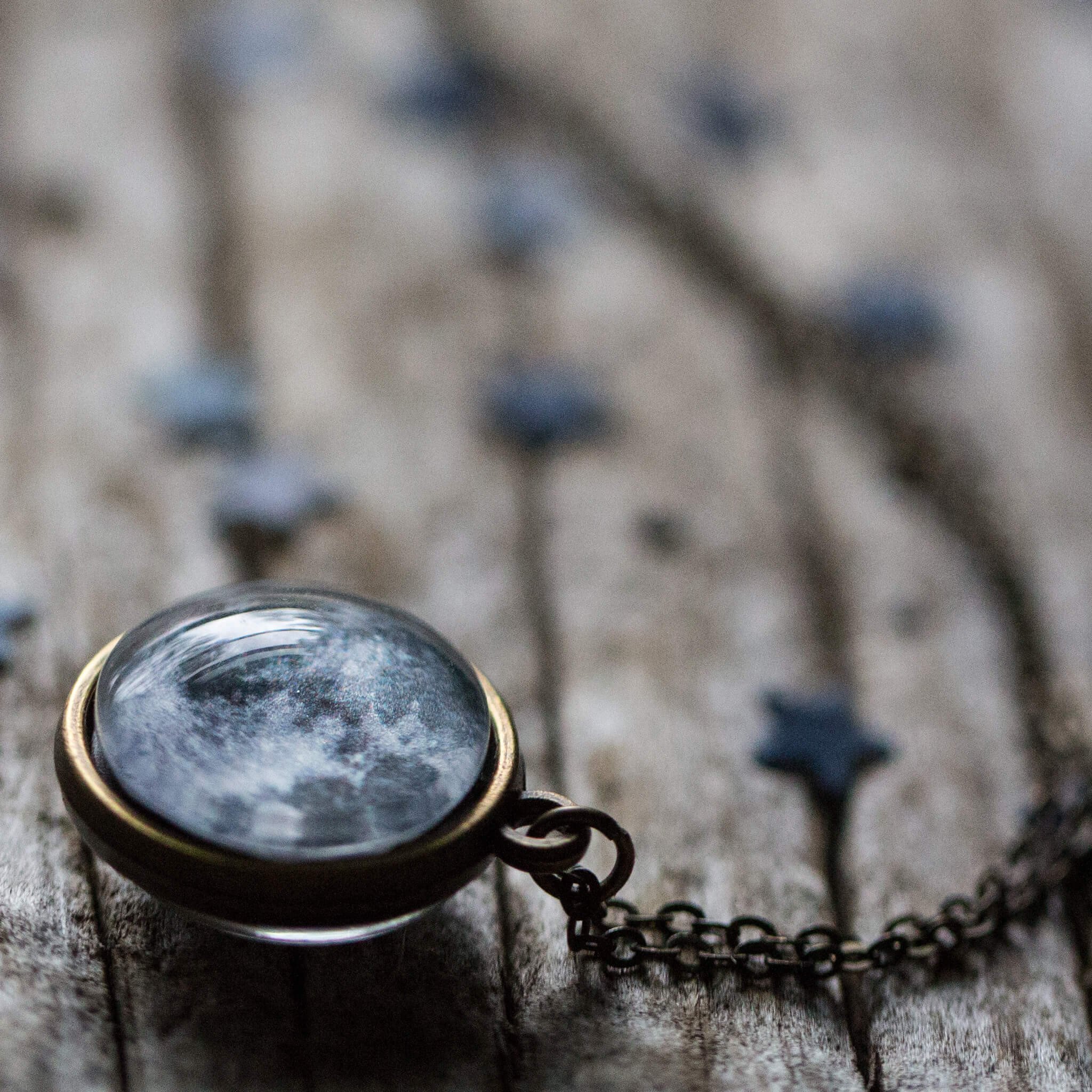 Double Sided Moon Necklace featuring the moon's face and dark side, available in antique bronze and silver tones.