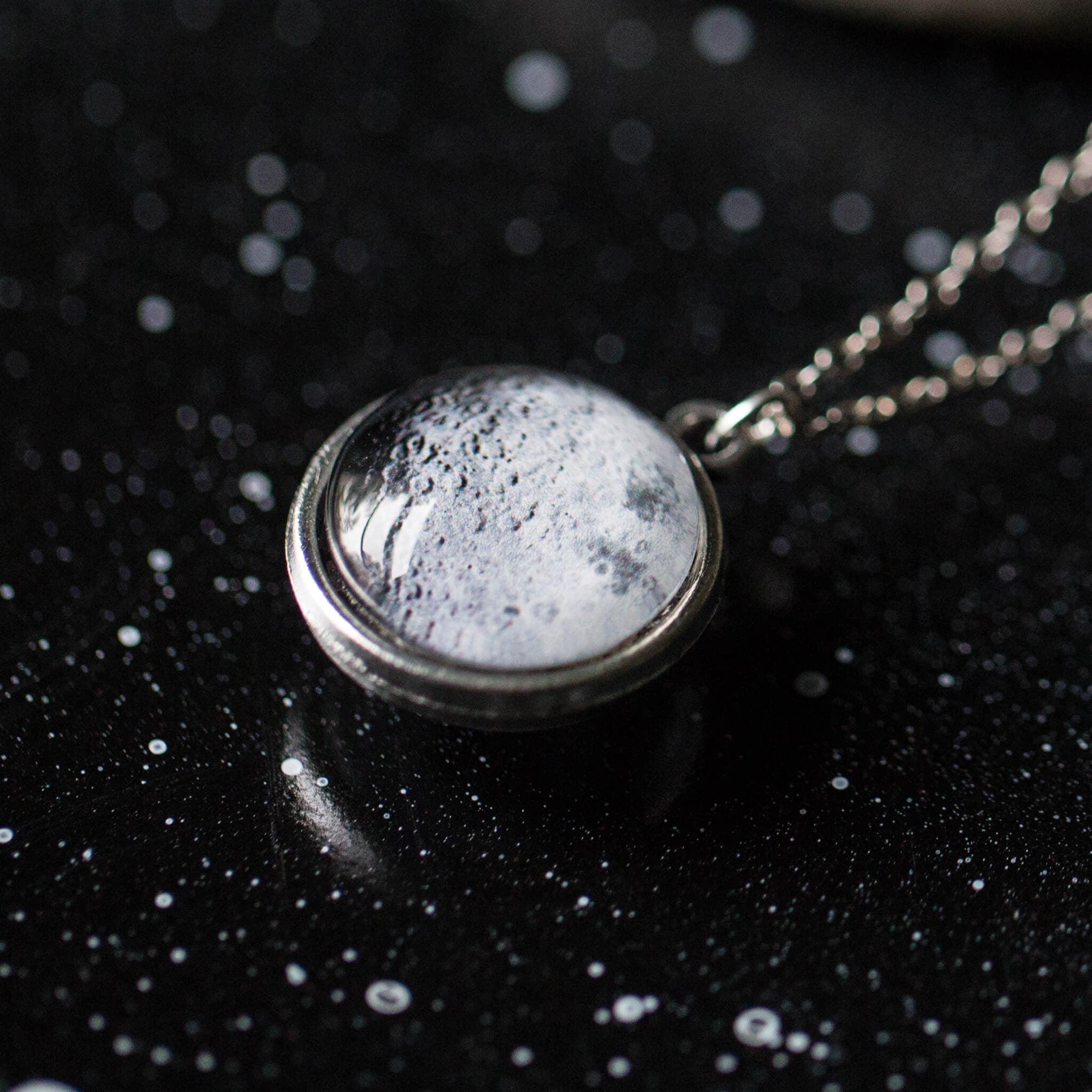 Double Sided Moon Necklace featuring the moon's face and dark side, available in antique bronze and silver tones.