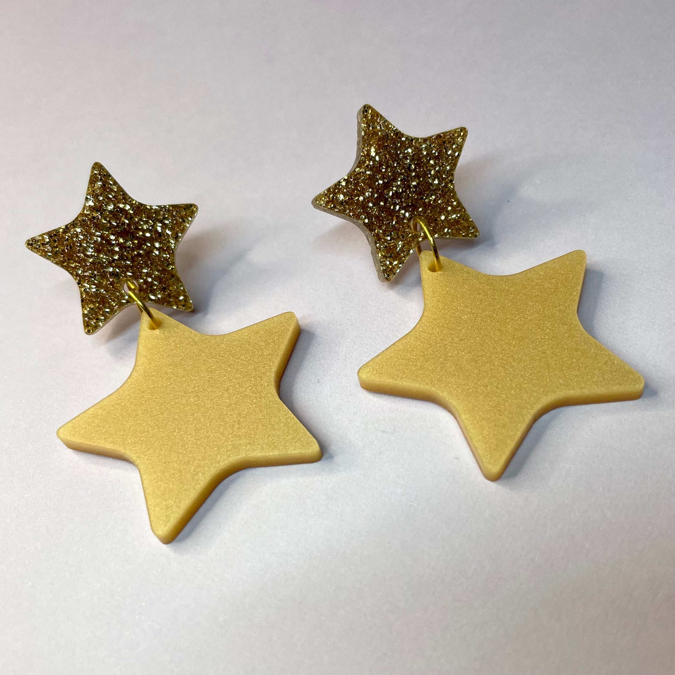 A pair of elegant Double Star Dangle Earrings made from laser-cut acrylic, featuring a unique design with a height of 5.5cm and width of 3.25cm.