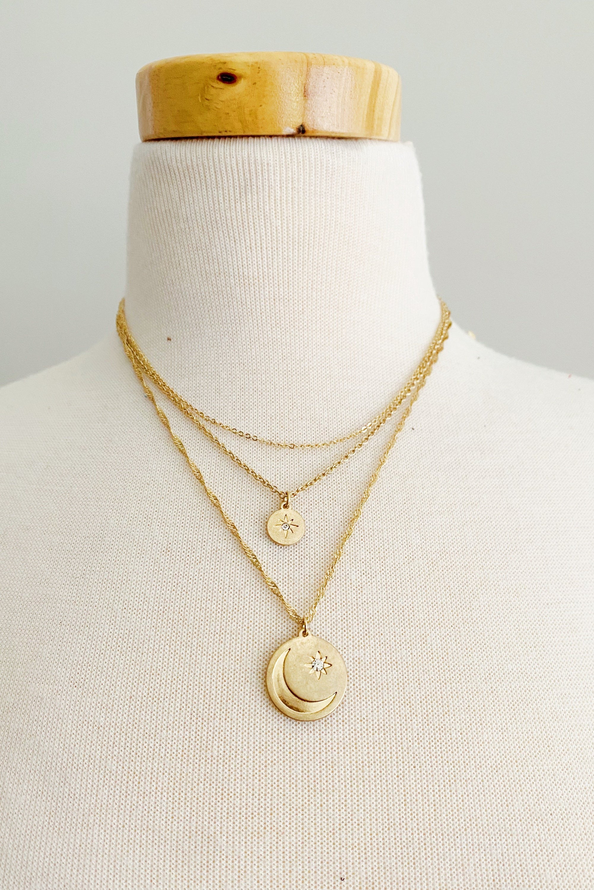 Double Star Layered Necklace featuring three chains with worn gold finish charms, adjustable length, and stylish design.