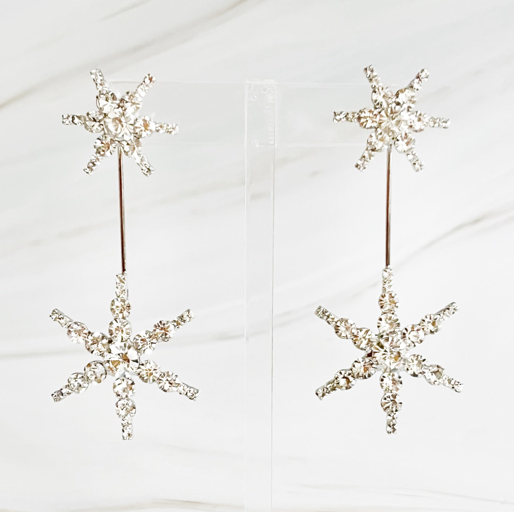 Elegant Double Starburst Statement Earrings featuring a sparkly starburst design in 18k gold plated brass with glass stones.