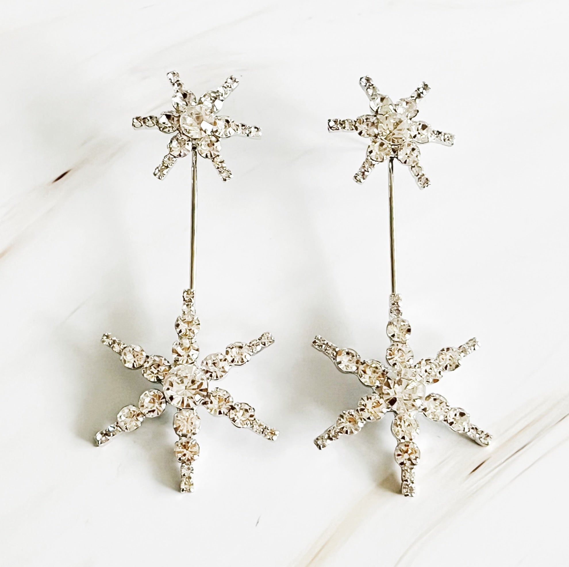 Elegant Double Starburst Statement Earrings featuring a sparkly starburst design in 18k gold plated brass with glass stones.