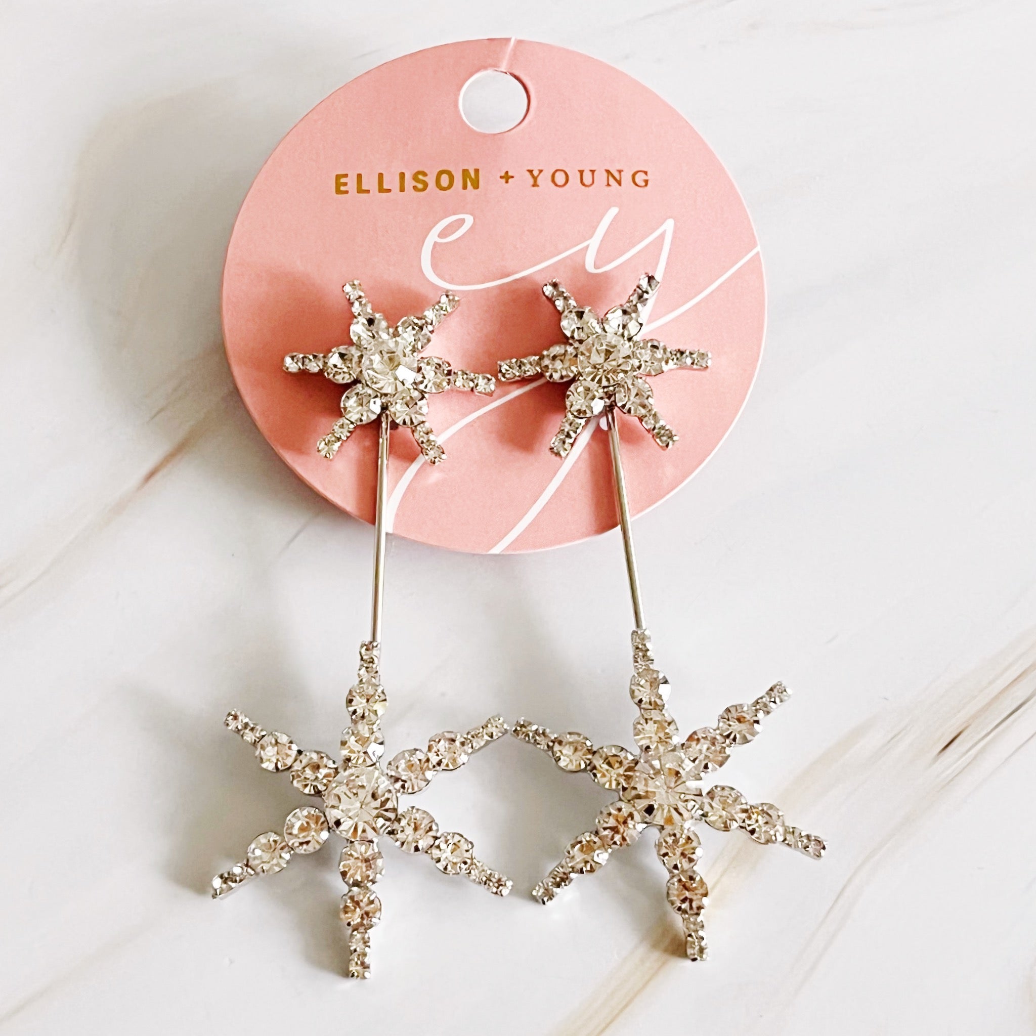 Elegant Double Starburst Statement Earrings featuring a sparkly starburst design in 18k gold plated brass with glass stones.