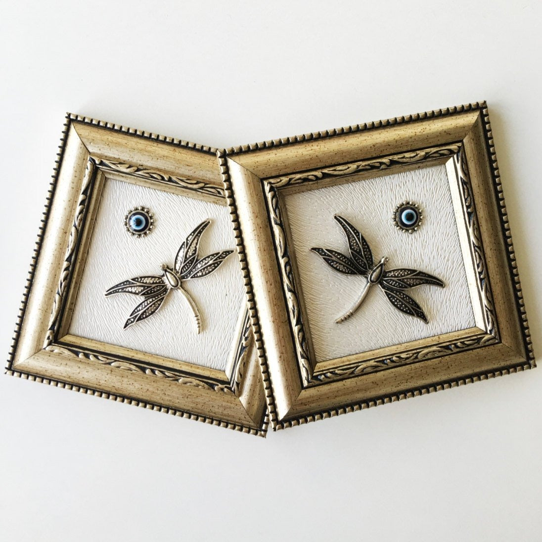 Handmade Dragonfly Framed Wall Decor featuring a silver dragonfly and a small evil eye bead, perfect for home decoration.