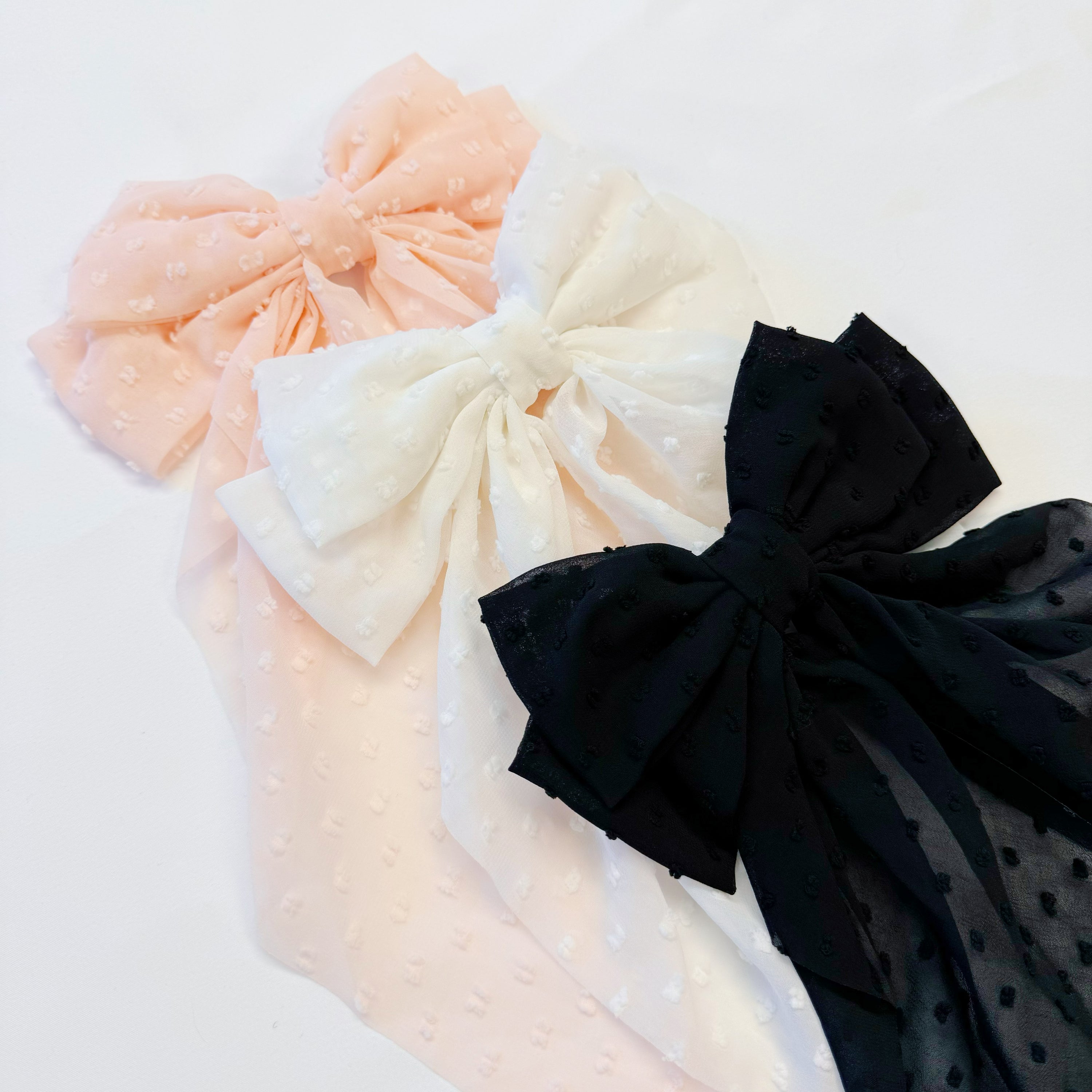 Dreamy Dotty Sheer Bow Hair Clip featuring a delicate sheer fabric and a playful dot pattern, perfect for adding elegance to any hairstyle.