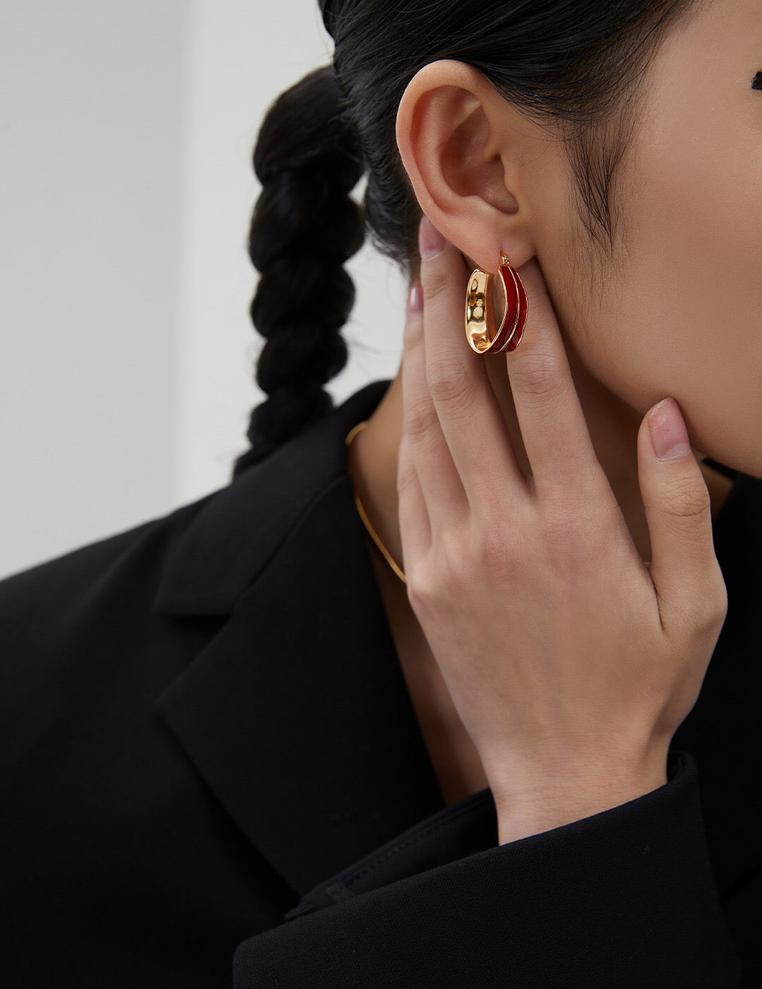 A pair of handmade Dripping Glaze Red Earrings featuring a vibrant red glaze and 18ct gold vermeil finish, elegantly displayed in a jewelry pouch.