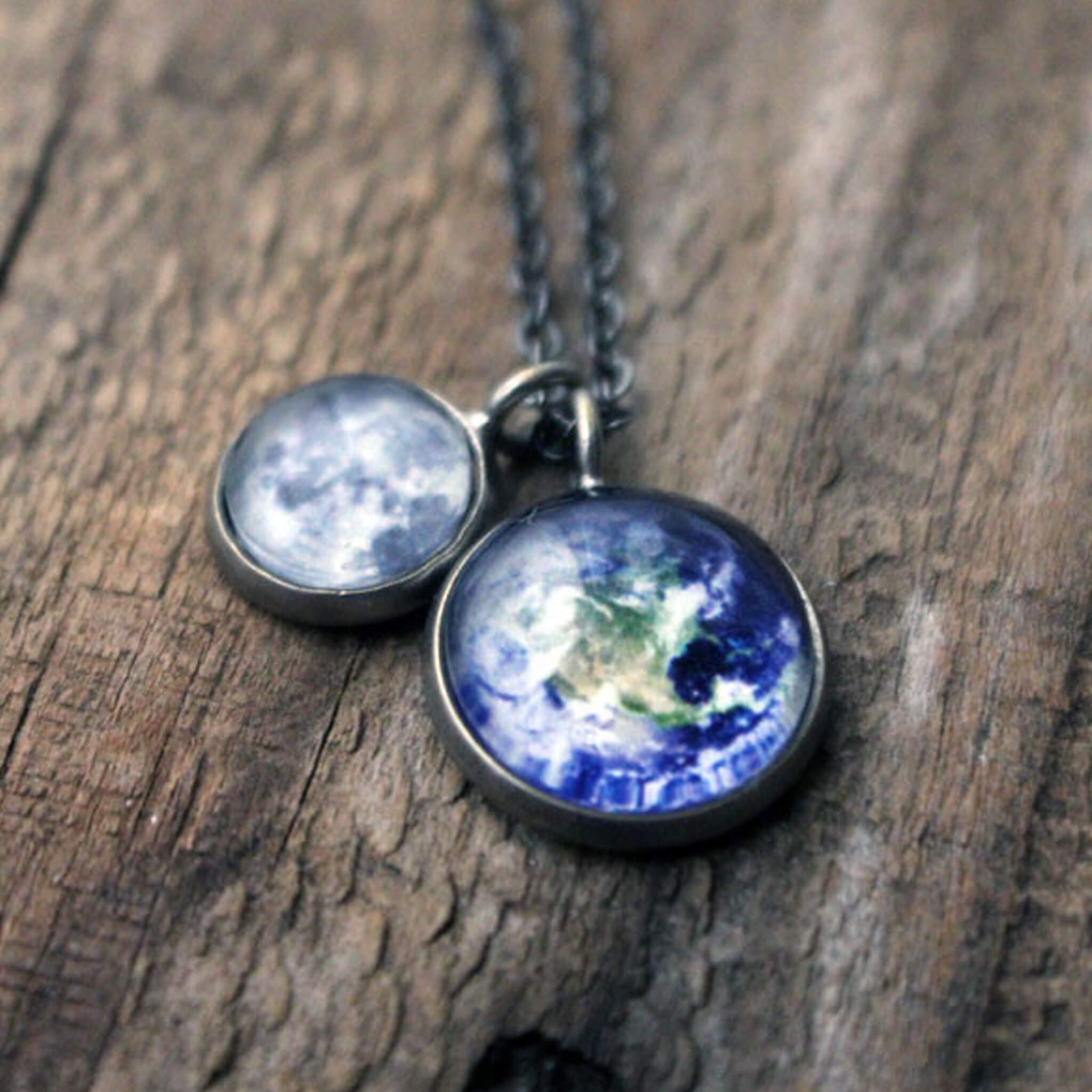 Earth and Moon Layered Space Necklace featuring a larger Earth pendant and a smaller Moon pendant, handcrafted with rhodium plated brass.