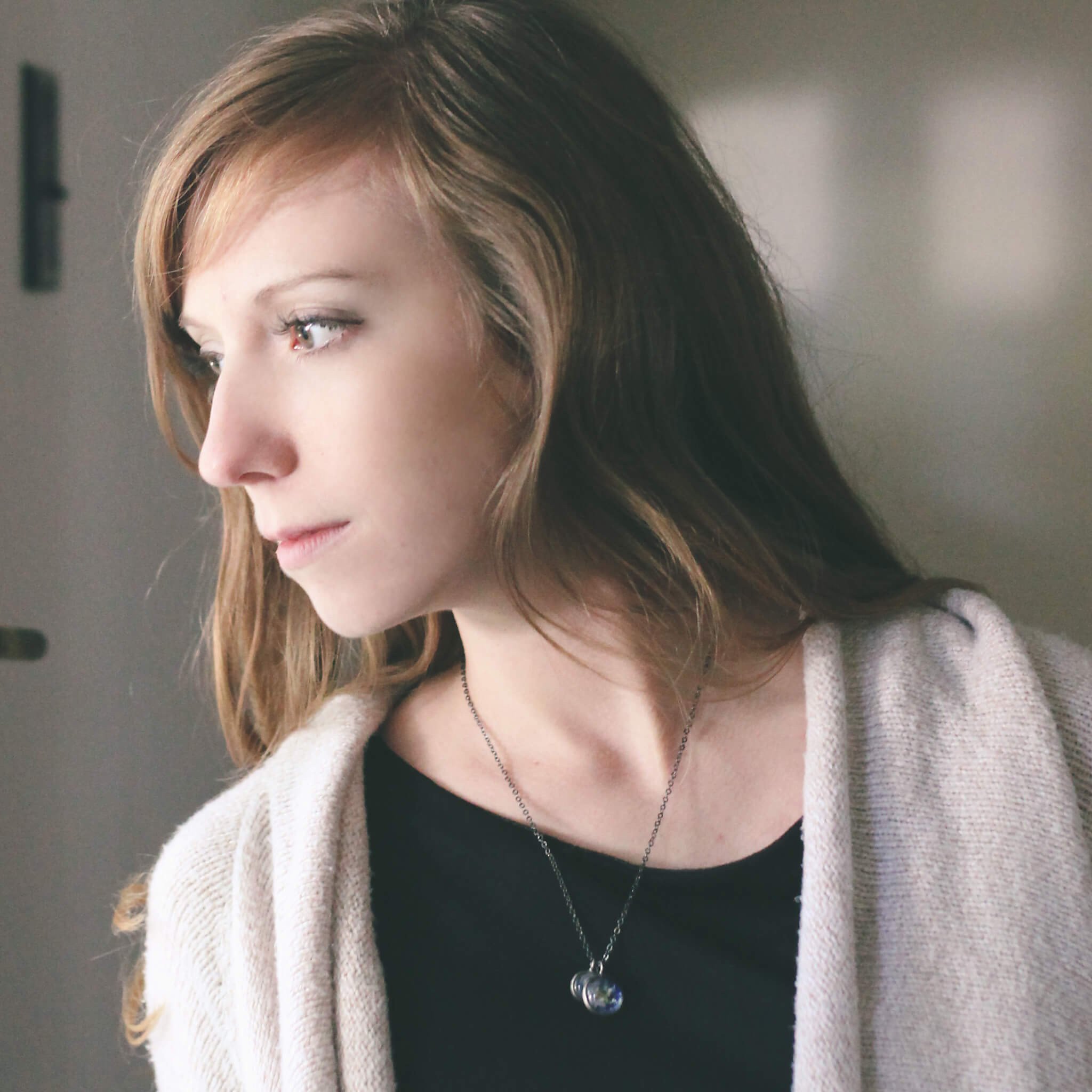 Earth and Moon Layered Space Necklace featuring a larger Earth pendant and a smaller Moon pendant, handcrafted with rhodium plated brass.