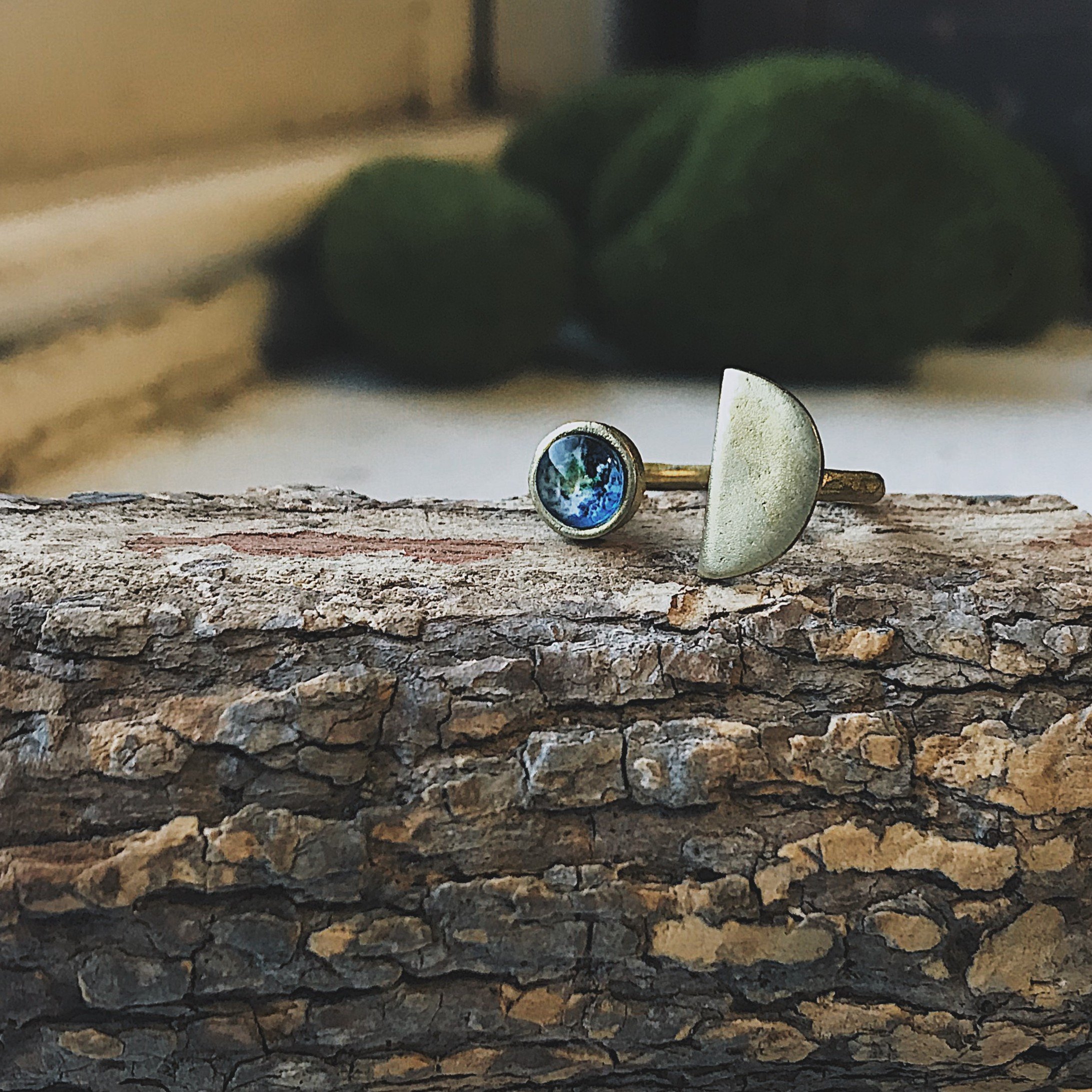 Earth Rise Ring featuring a glass image of Earth from the Moon, handcrafted in rhodium plated brass, available in silver and gold tones.