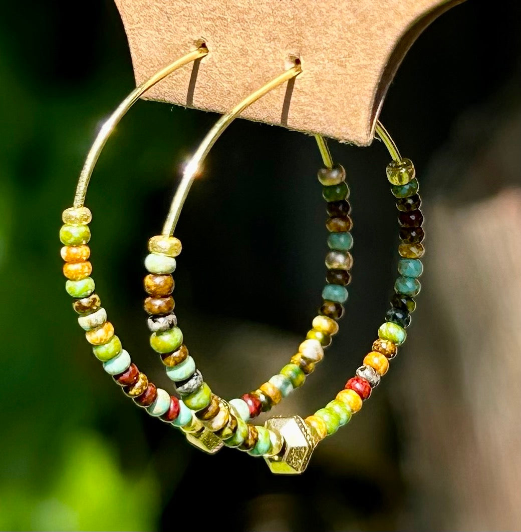 A pair of Earthy Greens & Gold Beaded Hoop Earrings featuring vibrant green and brown seed beads on a gold hoop.