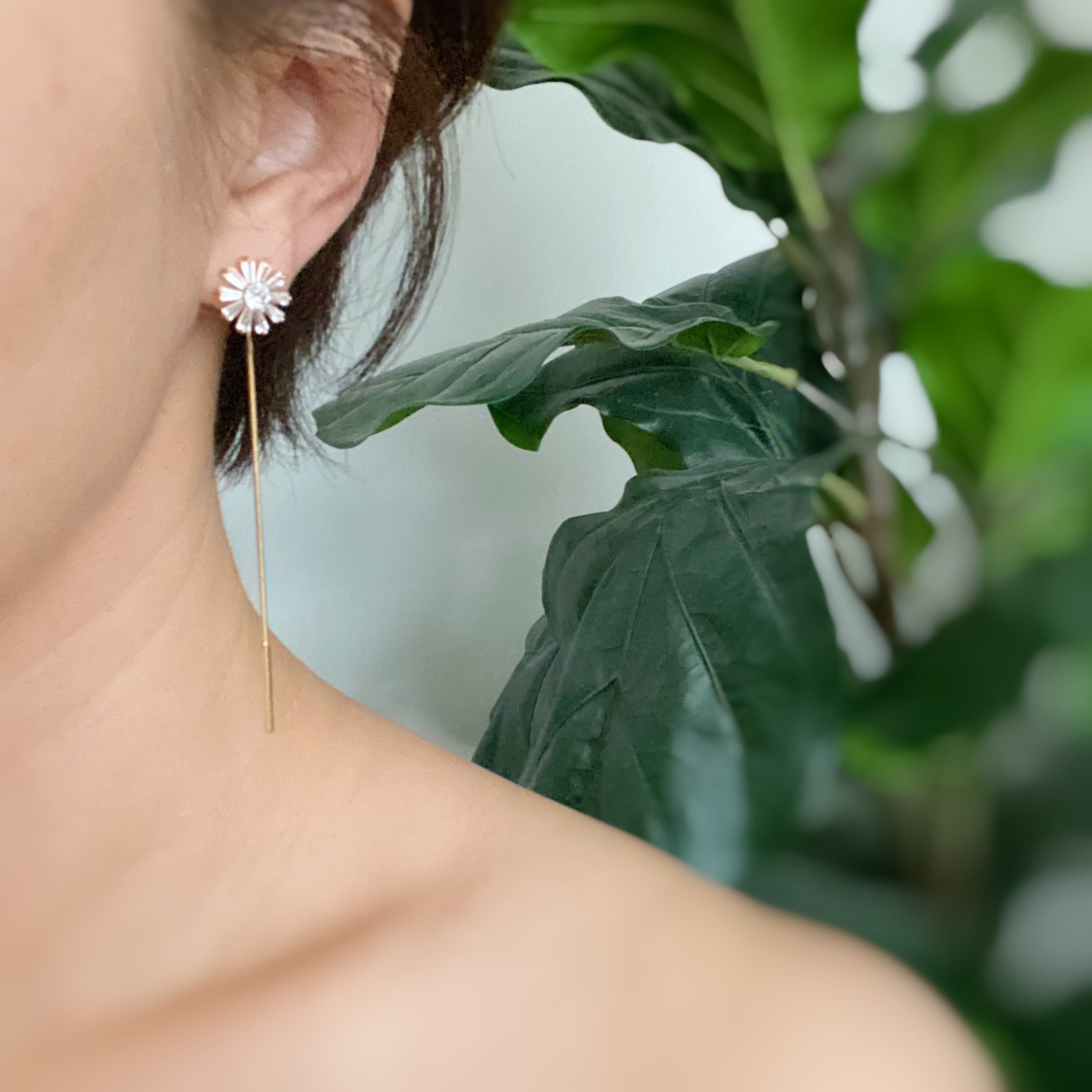 Edelweiss Backdrop Earrings featuring a sparkly flower stud and chain dangle, elegantly displayed on a soft background.