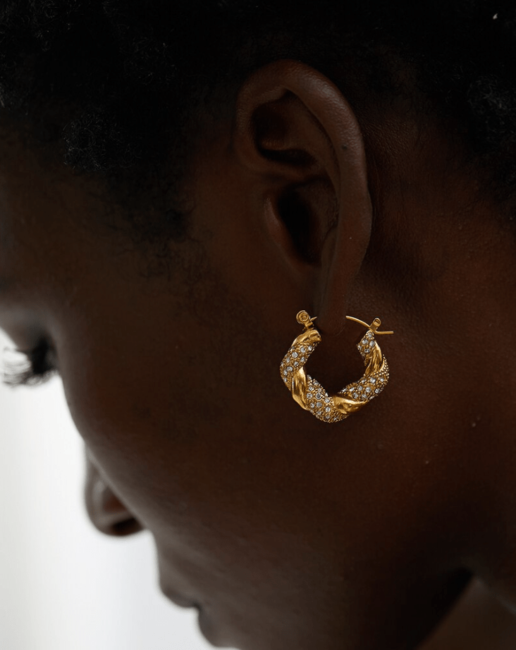 Elegant Egypt twist hoop earrings made of stainless steel with 18K gold PVD plating and zircon crystal pavé, showcasing a unique twist design.