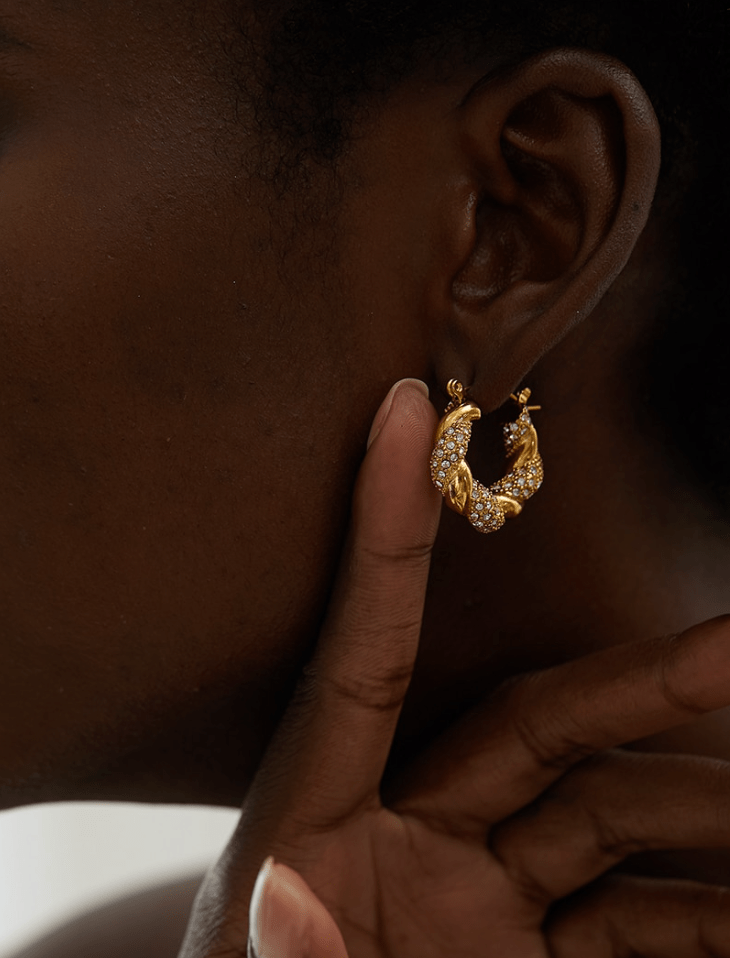 Elegant Egypt twist hoop earrings made of stainless steel with 18K gold PVD plating and zircon crystal pavé, showcasing a unique twist design.