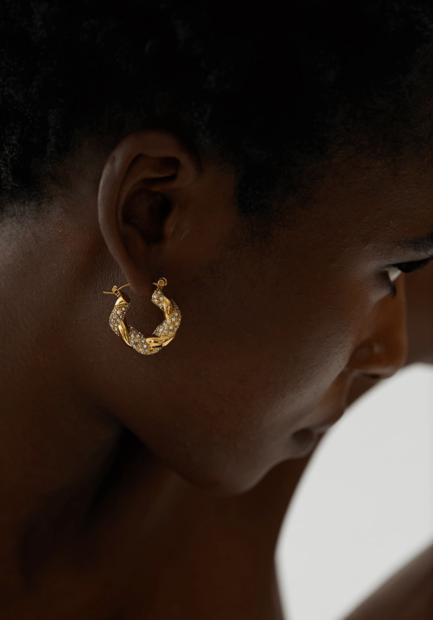 Elegant Egypt twist hoop earrings made of stainless steel with 18K gold PVD plating and zircon crystal pavé, showcasing a unique twist design.