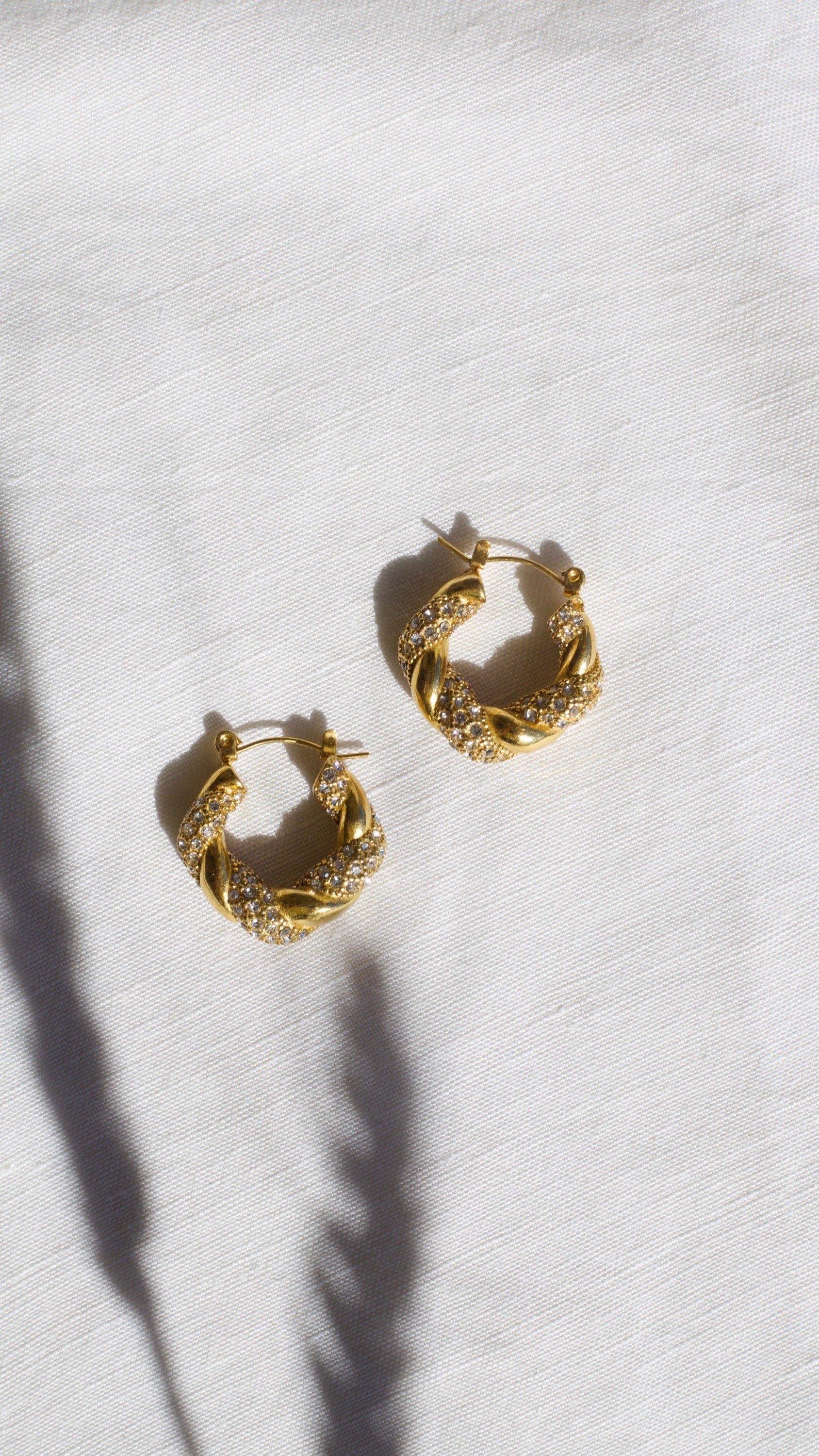 Elegant Egypt twist hoop earrings made of stainless steel with 18K gold PVD plating and zircon crystal pavé, showcasing a unique twist design.