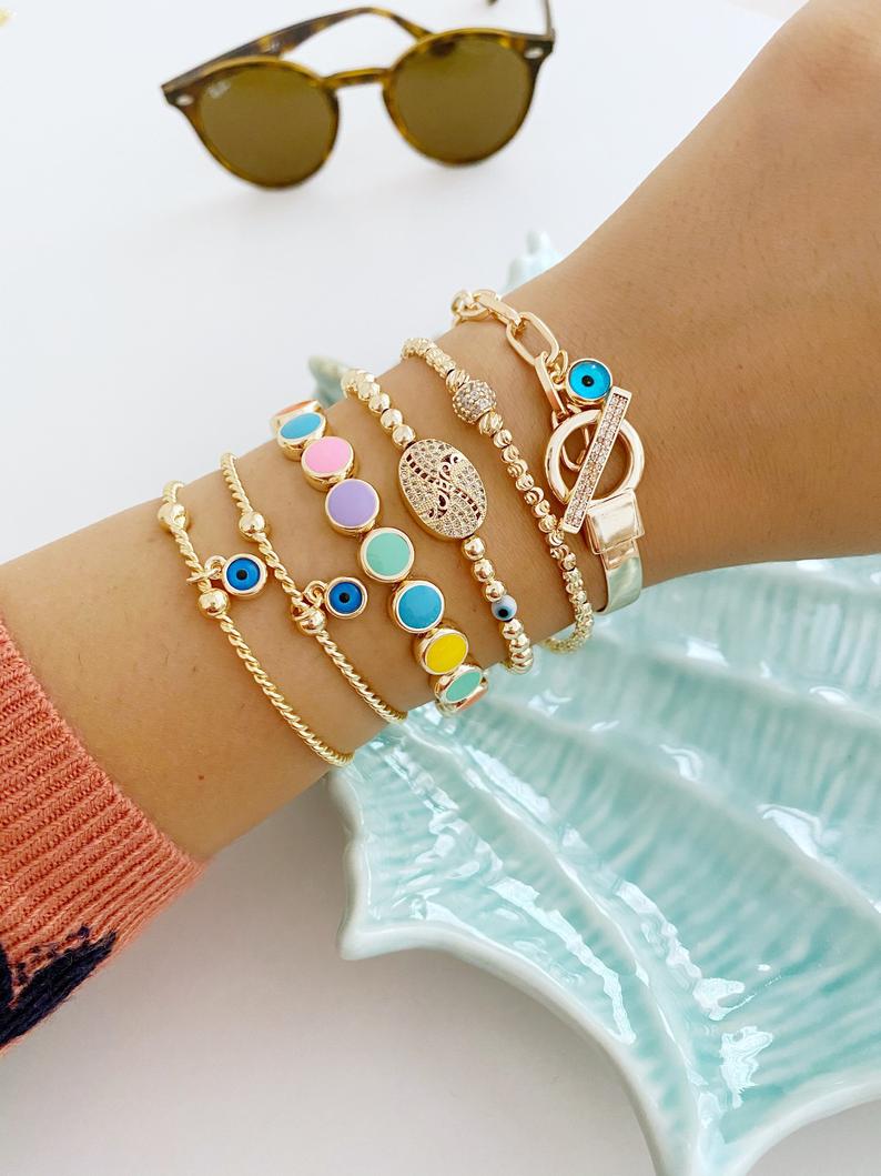 Elegant Evil Eye Bracelet featuring a gold bangle design, handmade with tarnish-resistant stainless steel, adjustable for all wrist sizes.