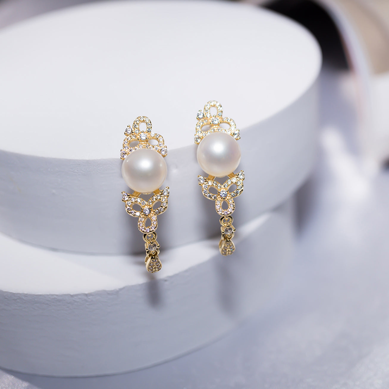 Elegant Freshwater Pearl Earrings featuring a round white pearl, sterling silver, and cubic zirconia accents, inspired by traditional Chinese knots.