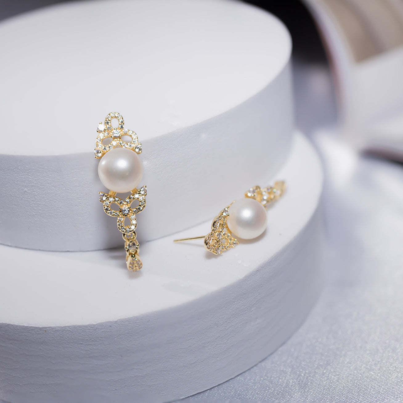 Elegant Freshwater Pearl Earrings featuring a round white pearl, sterling silver, and cubic zirconia accents, inspired by traditional Chinese knots.