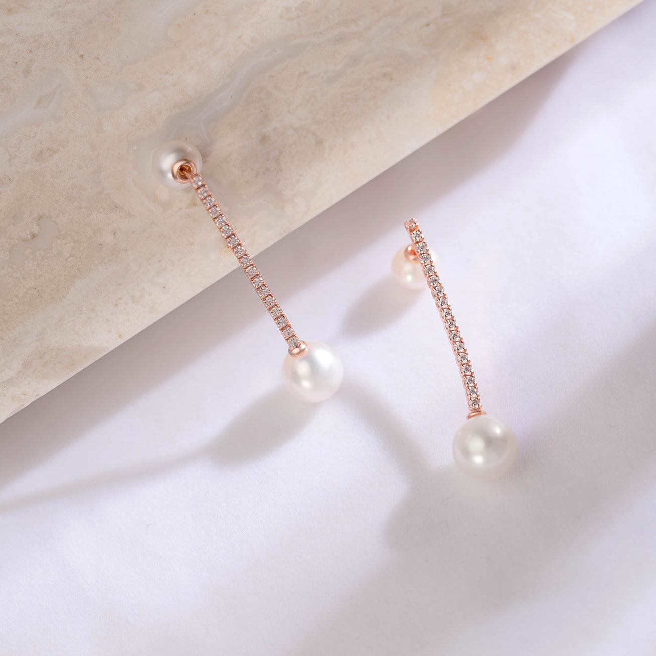 Elegant Freshwater Pearl Earrings featuring 8-9mm round white pearls, sterling silver, and rose gold plating.