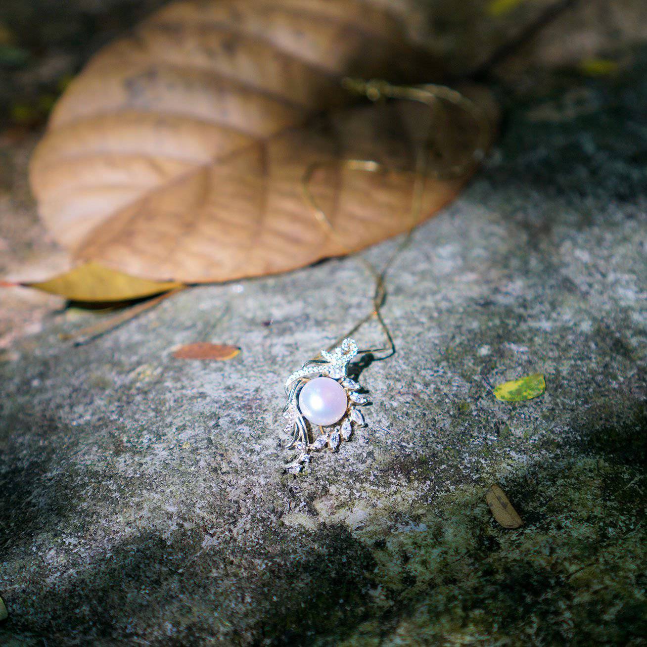 Elegant Freshwater Pearl Necklace featuring a white pearl surrounded by a gold-plated leaf design, adorned with cubic zirconia gemstones.